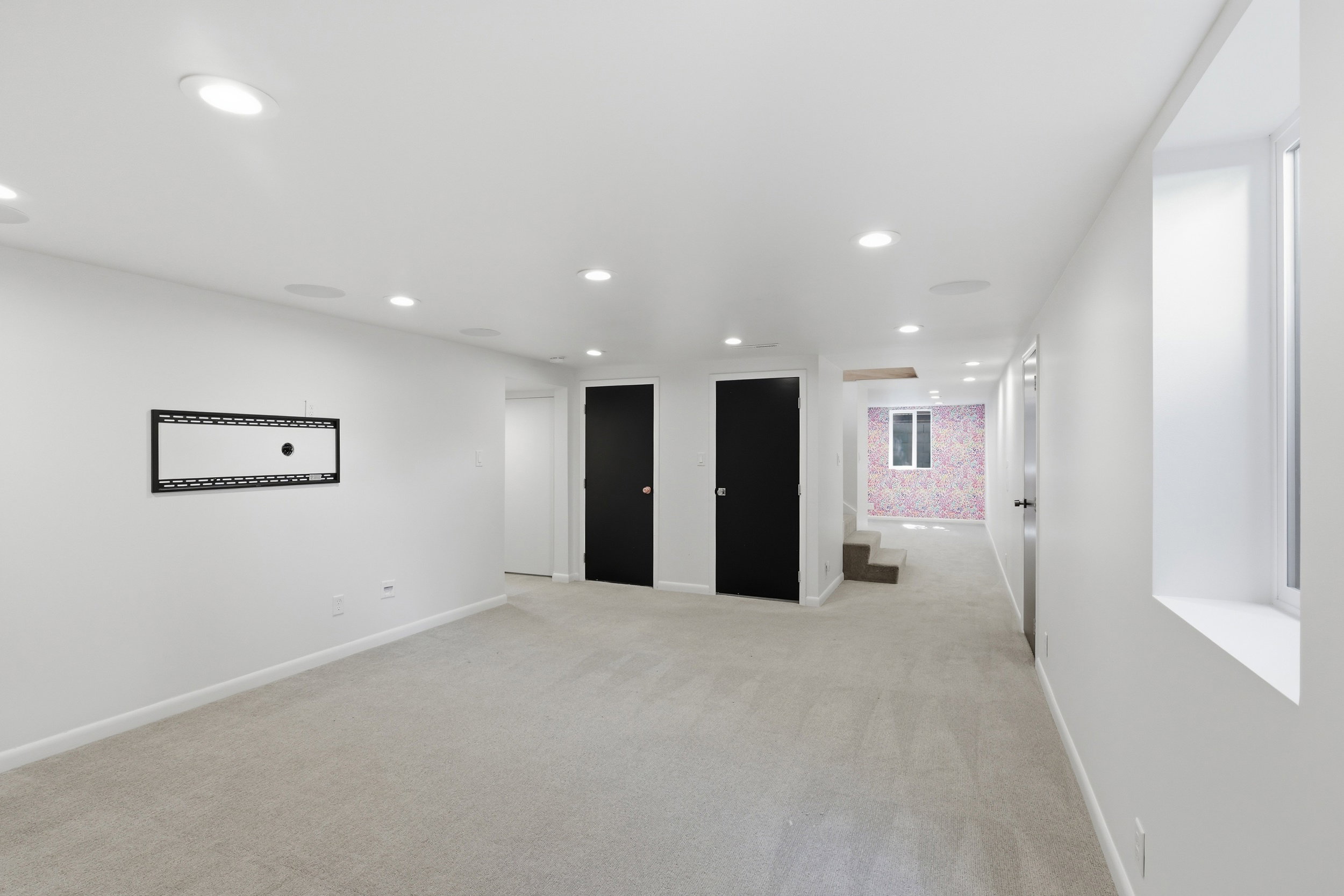 Spacious room featuring light gray carpet flooring, recessed ceiling lighting, and crisp white walls