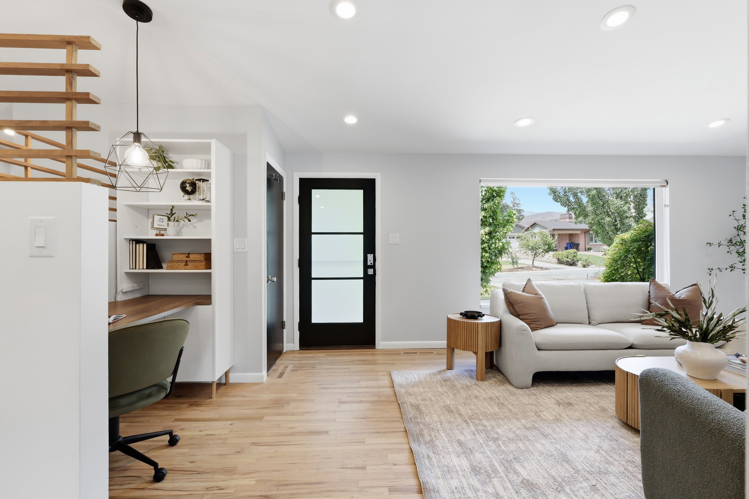 Bright living area featuring wood-finish flooring, recessed lighting, and a large picture window