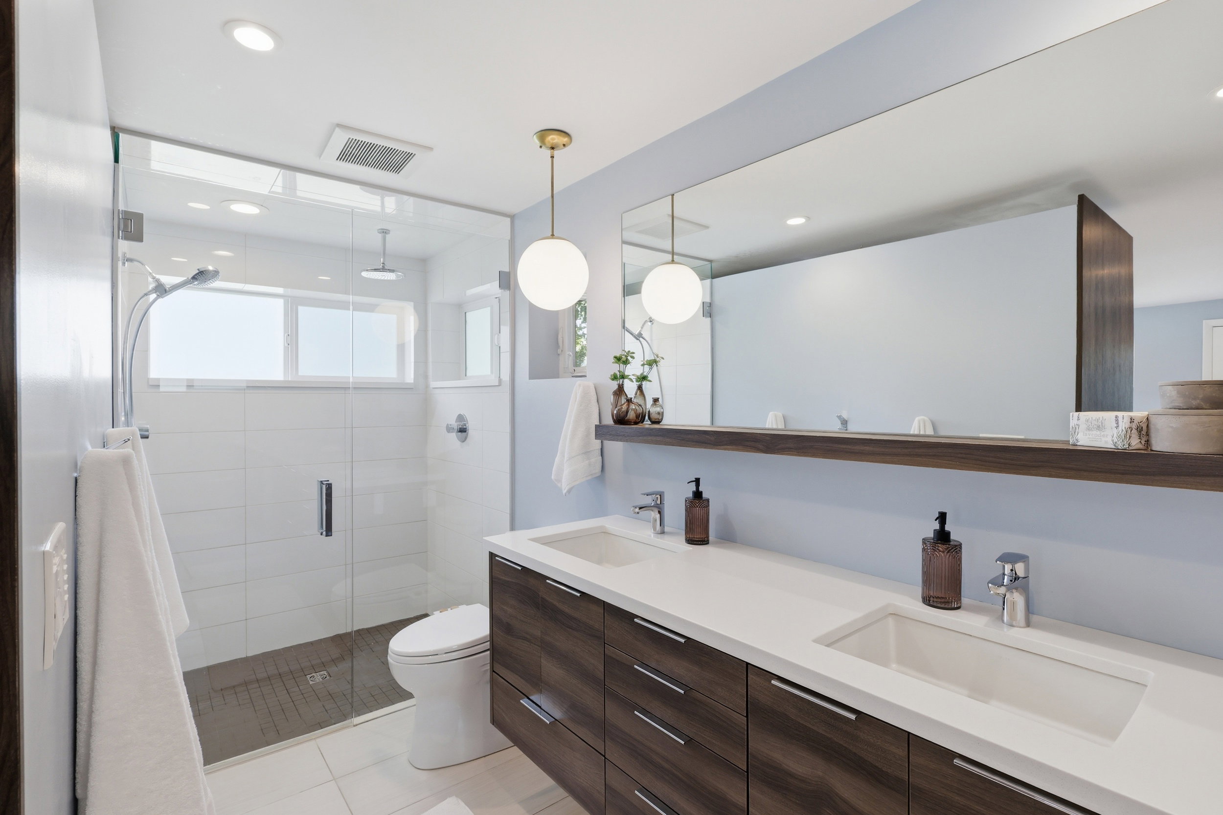 Modern bathroom featuring a double vanity with integrated sinks and wood-finish cabinetry