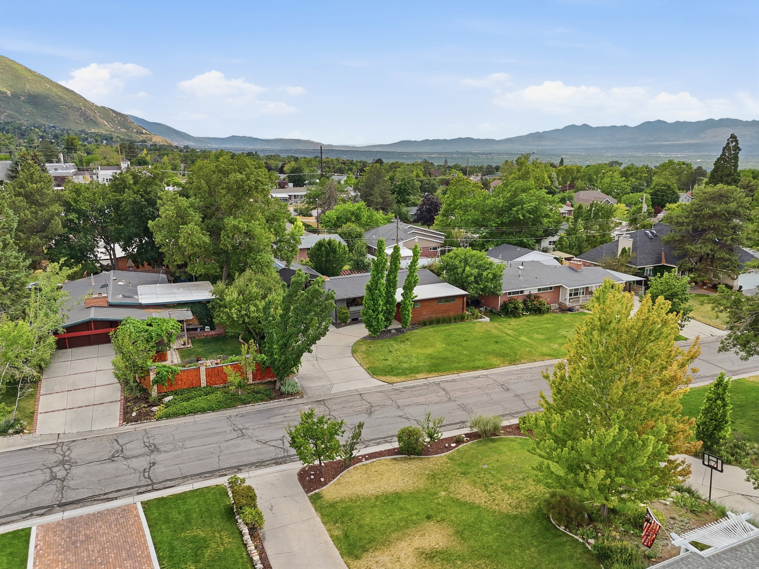 Lush suburban setting featuring mature trees and mountain backdrops