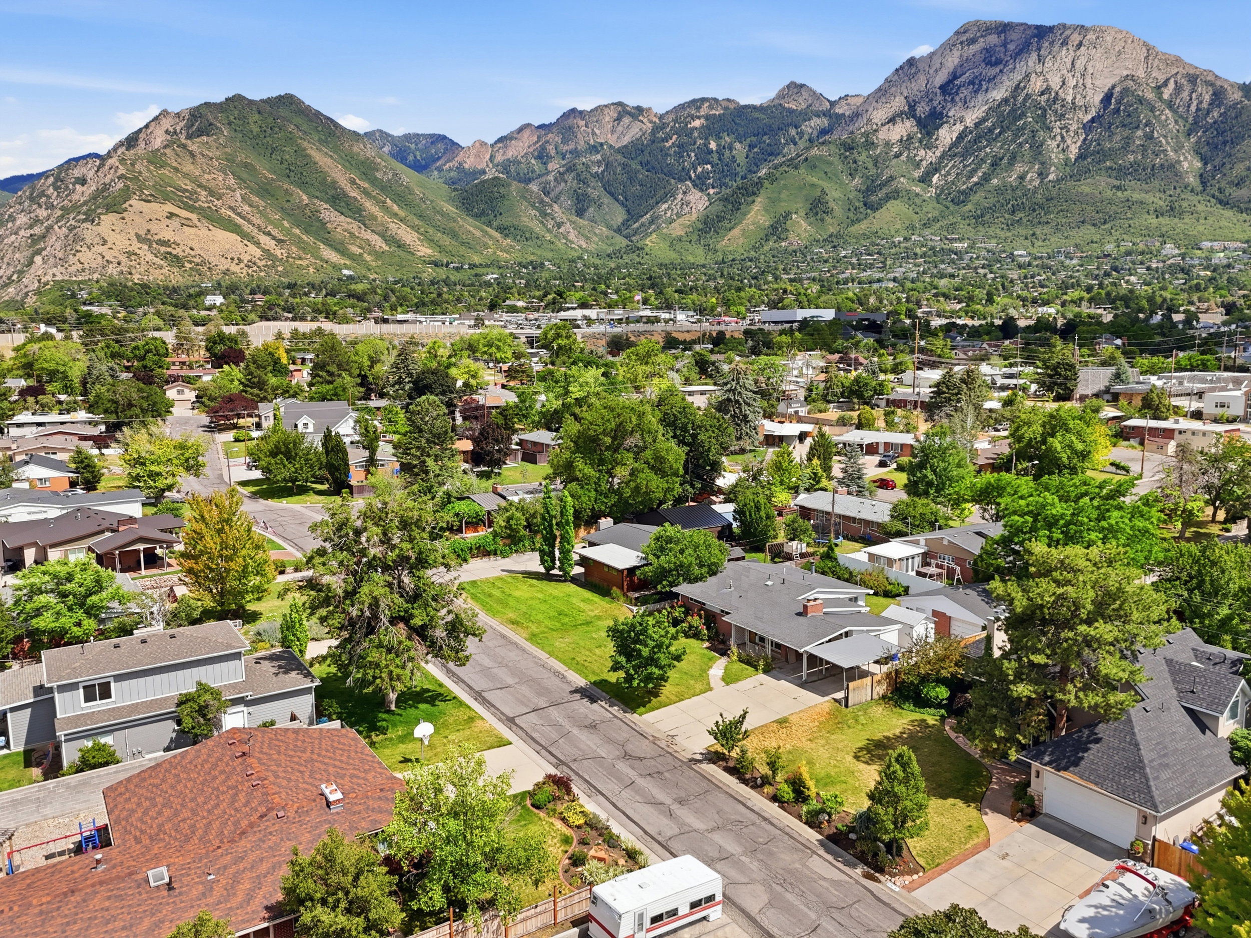 Mountain range backdrop with residential homes featuring mature trees