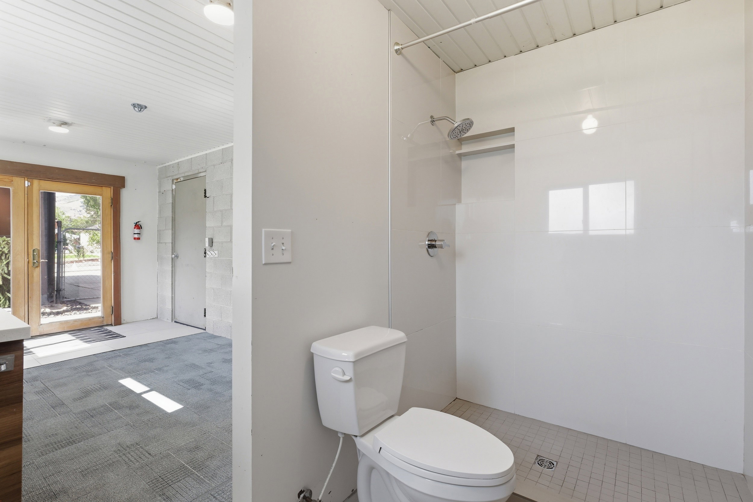 Walk-in shower with white paneling and chrome fixtures
