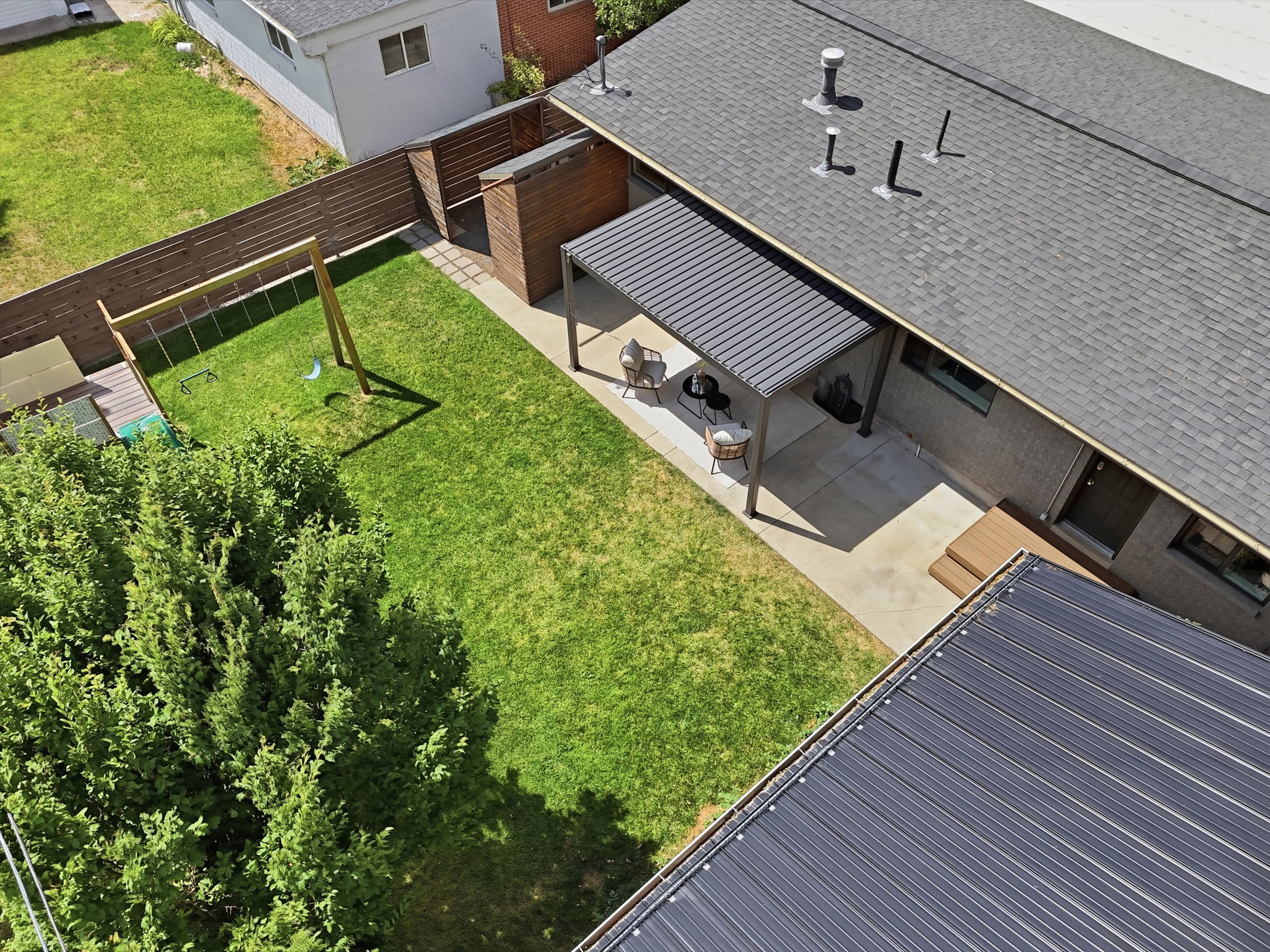 Expansive backyard featuring a lush lawn, mature perimeter shrubbery, and a sturdy privacy fence