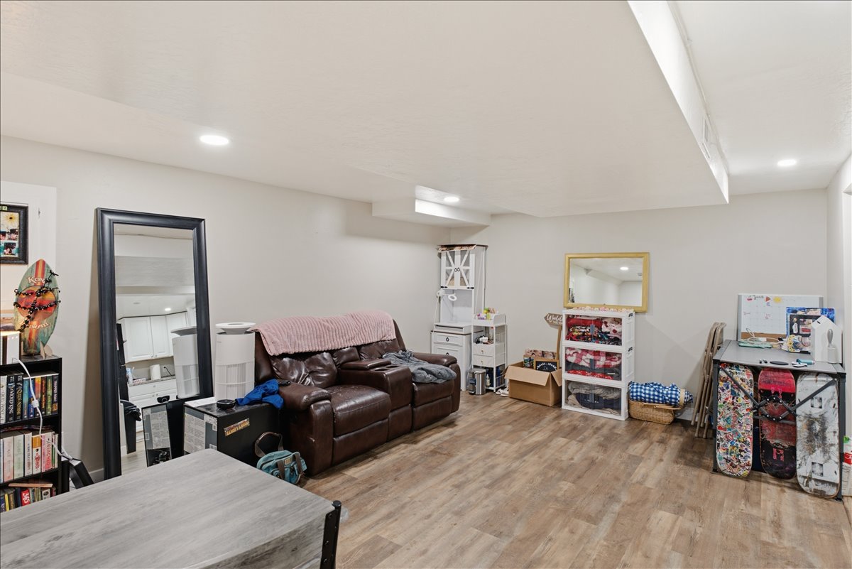 Spacious room featuring wood-finish flooring, recessed lighting, and light-toned walls