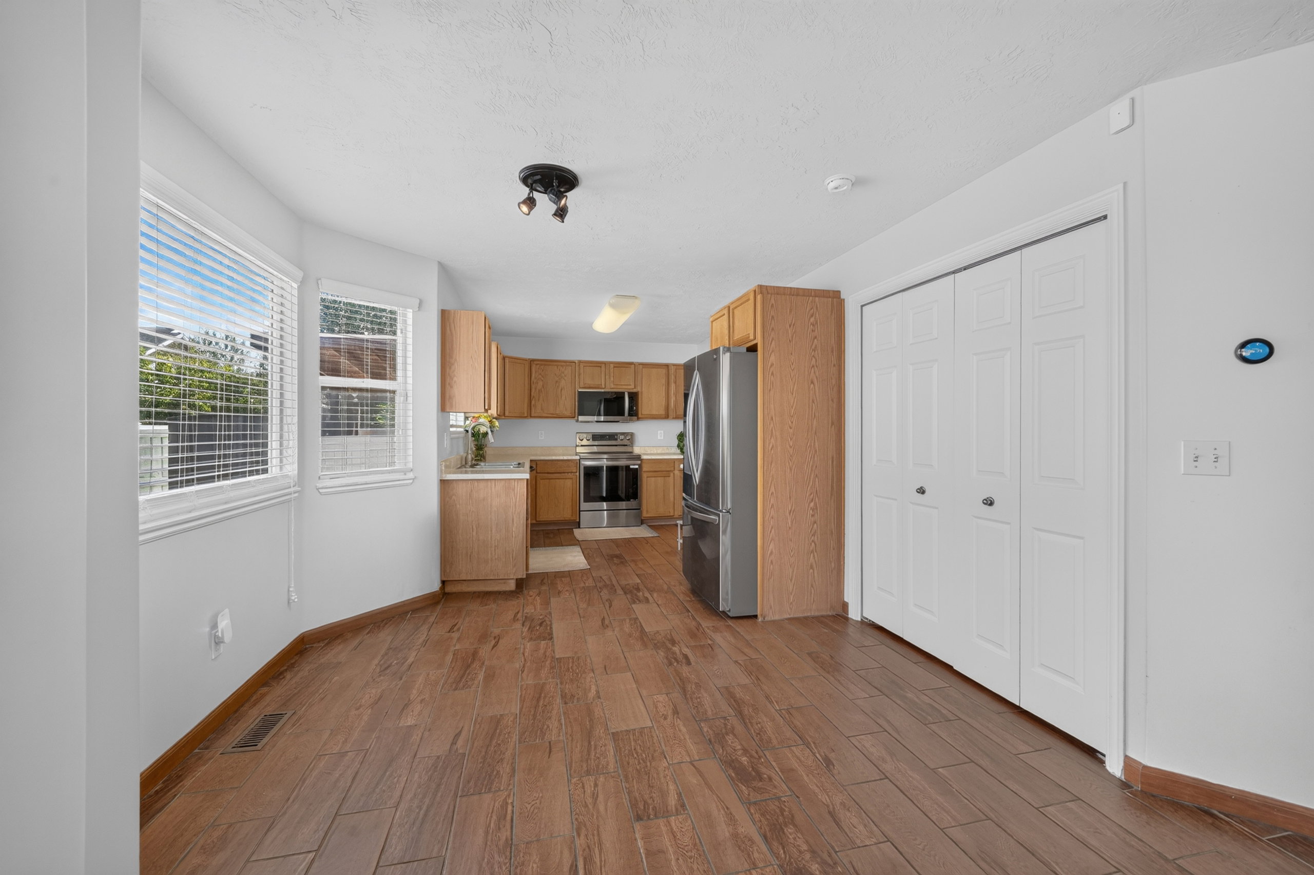 Kitchen area featuring wood-finish flooring and light wood cabinetry