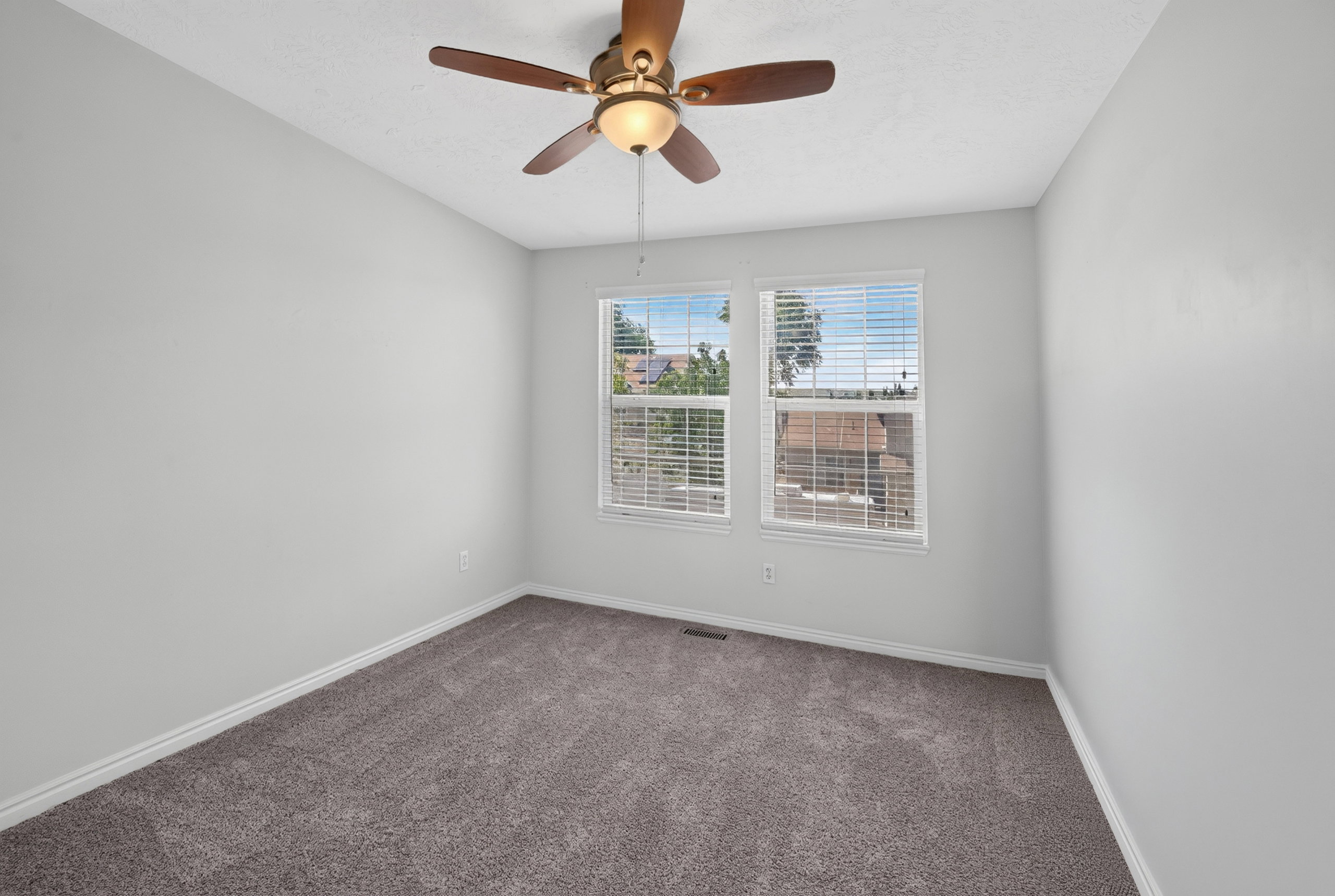 Room featuring light gray walls, gray carpeting, and white baseboards