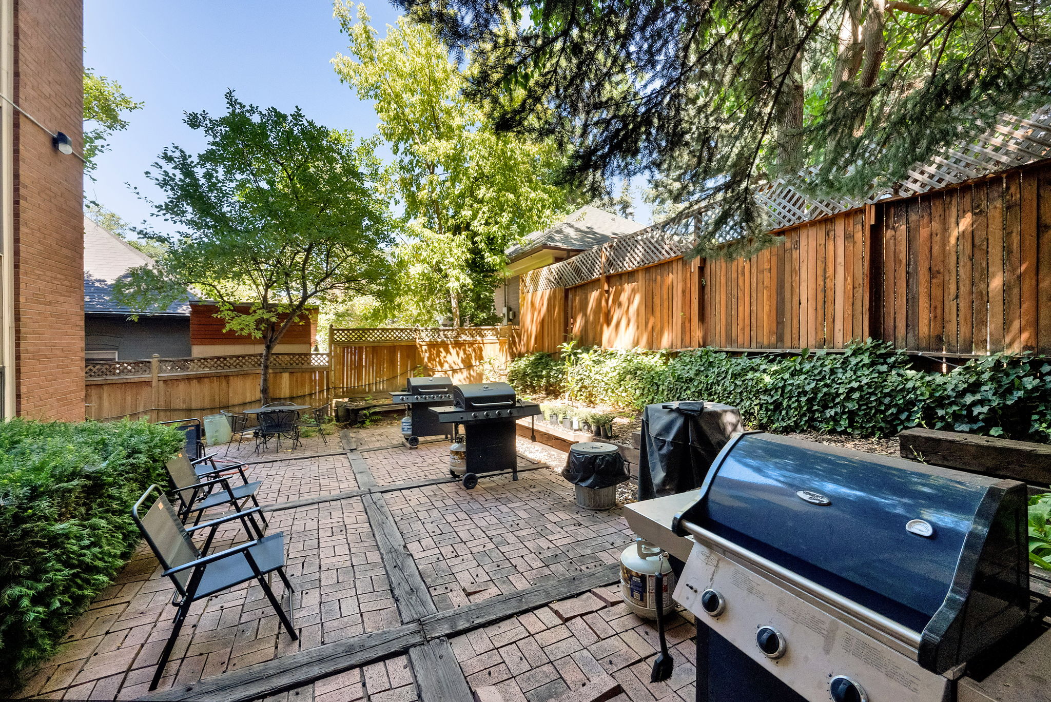 Expansive outdoor patio featuring brick pavers and wood-finish accents
