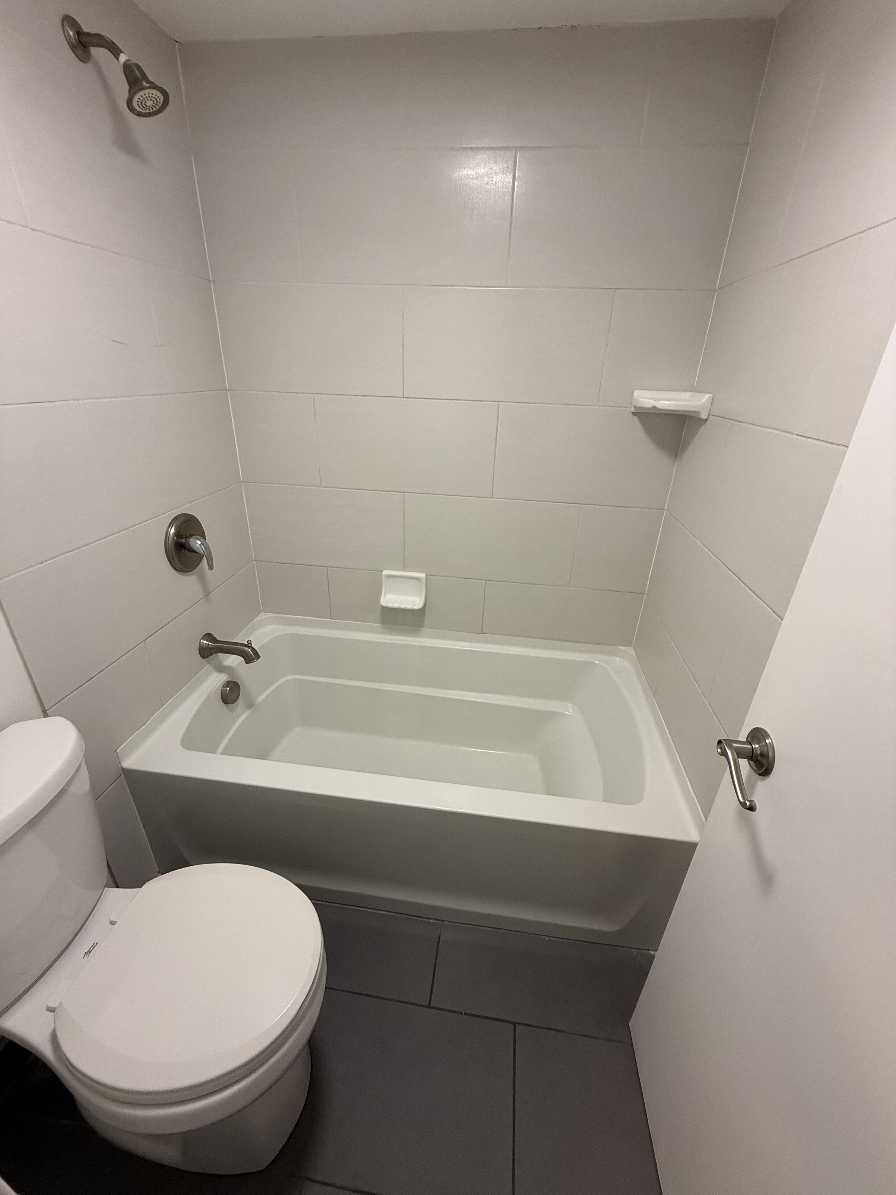 Full-size bathtub with a brushed nickel showerhead and faucet