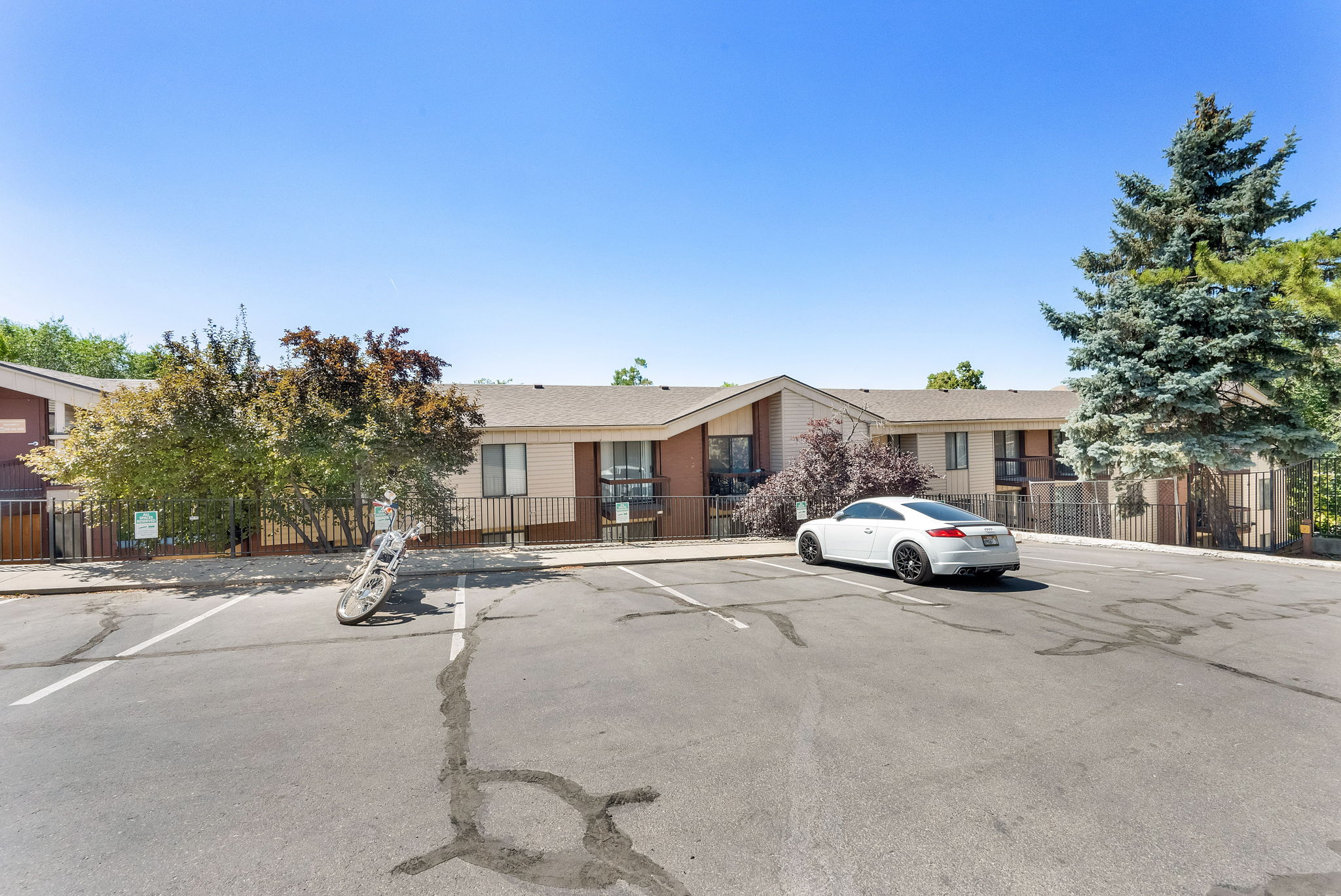 Multi-unit property with a paved parking area and mature landscaping