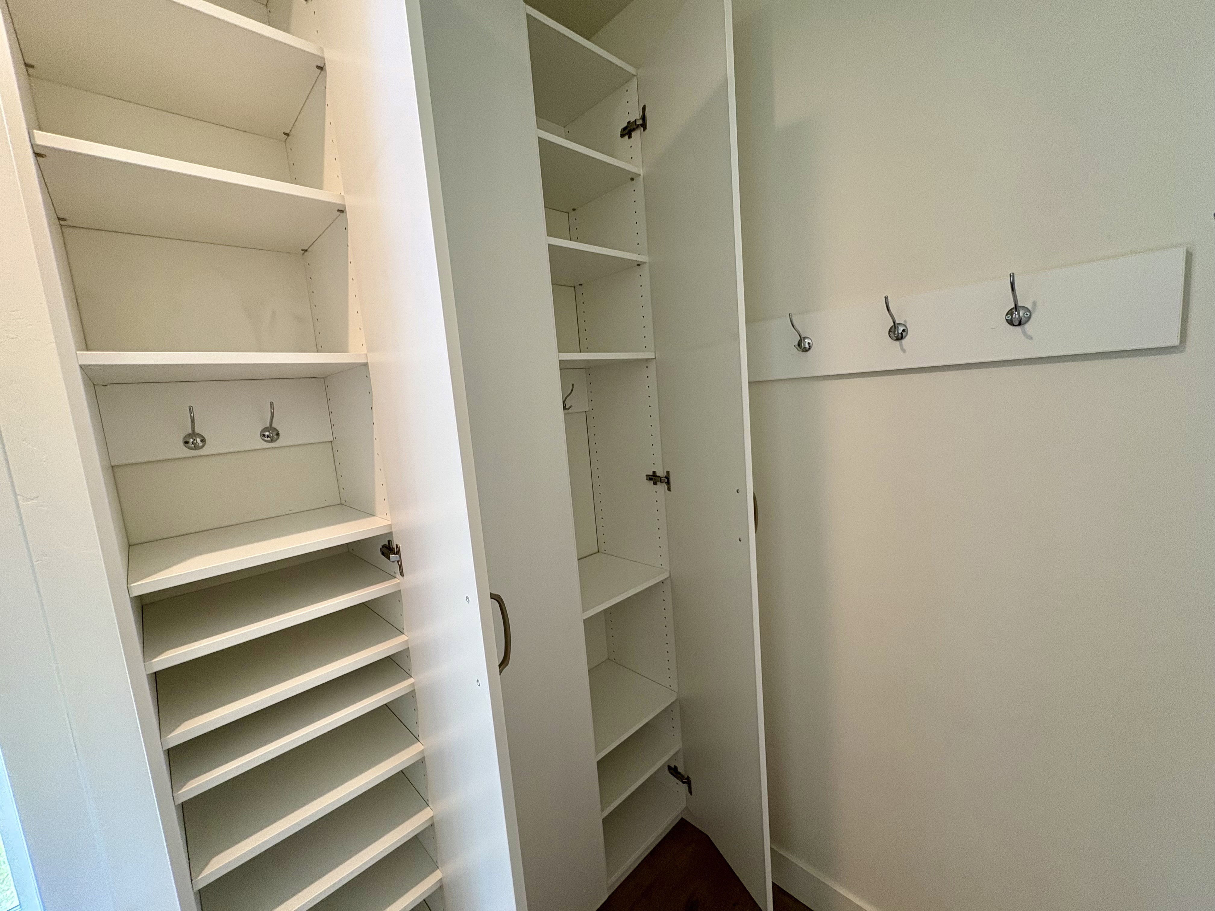 Built-in storage system in Mud room with adjustable shelving, shoe racks, and coat hooks