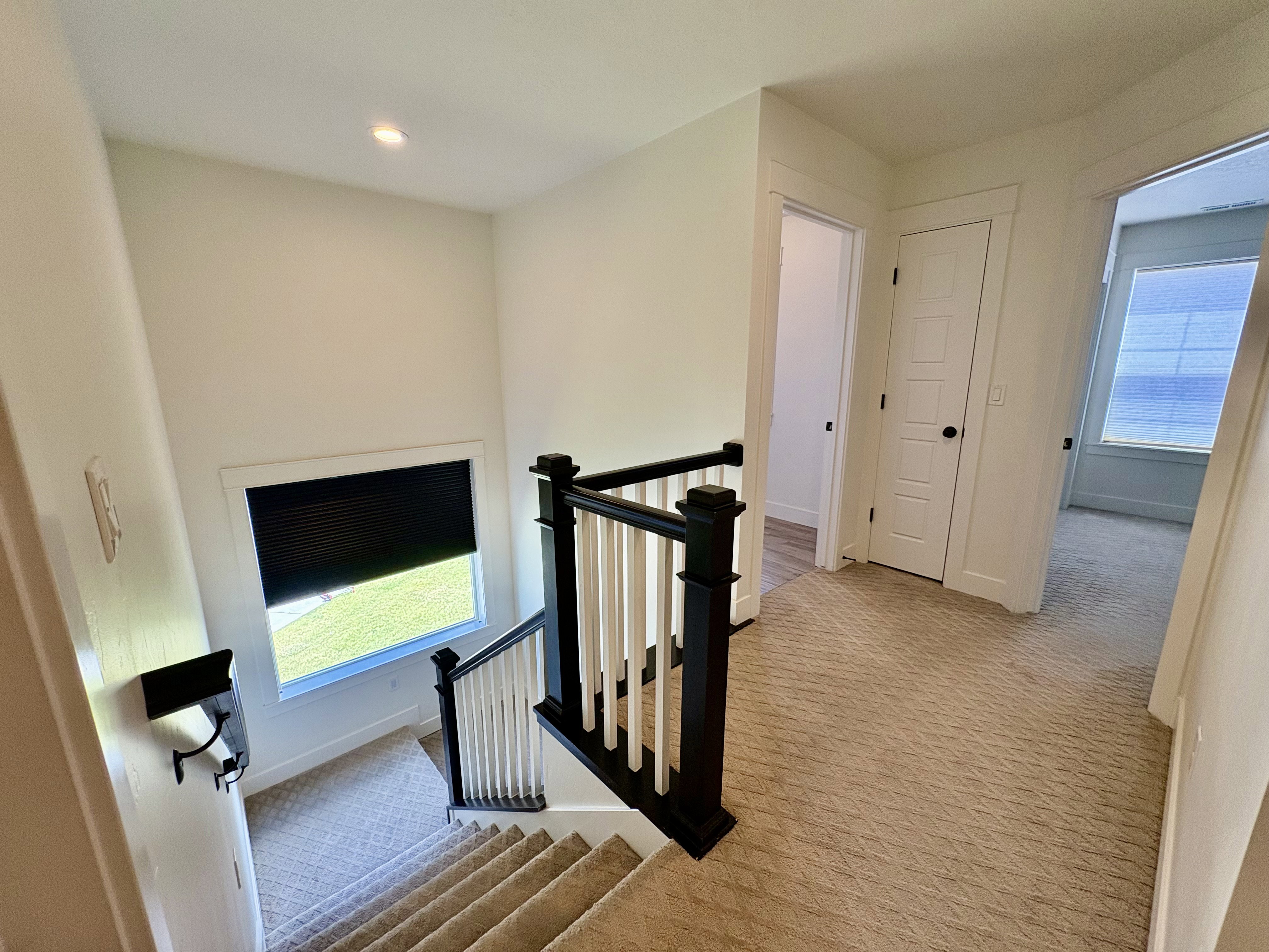 Second-level landing featuring neutral-toned patterned carpeting and white walls