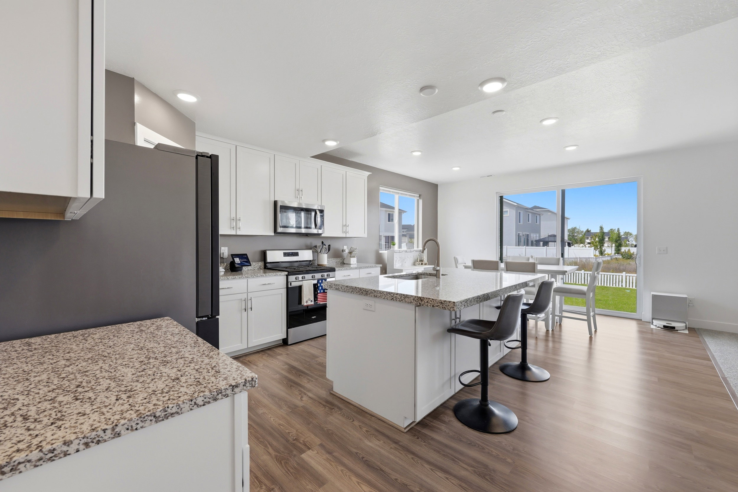 Contemporary kitchen featuring white cabinetry, stainless steel appliances, and granite countertops