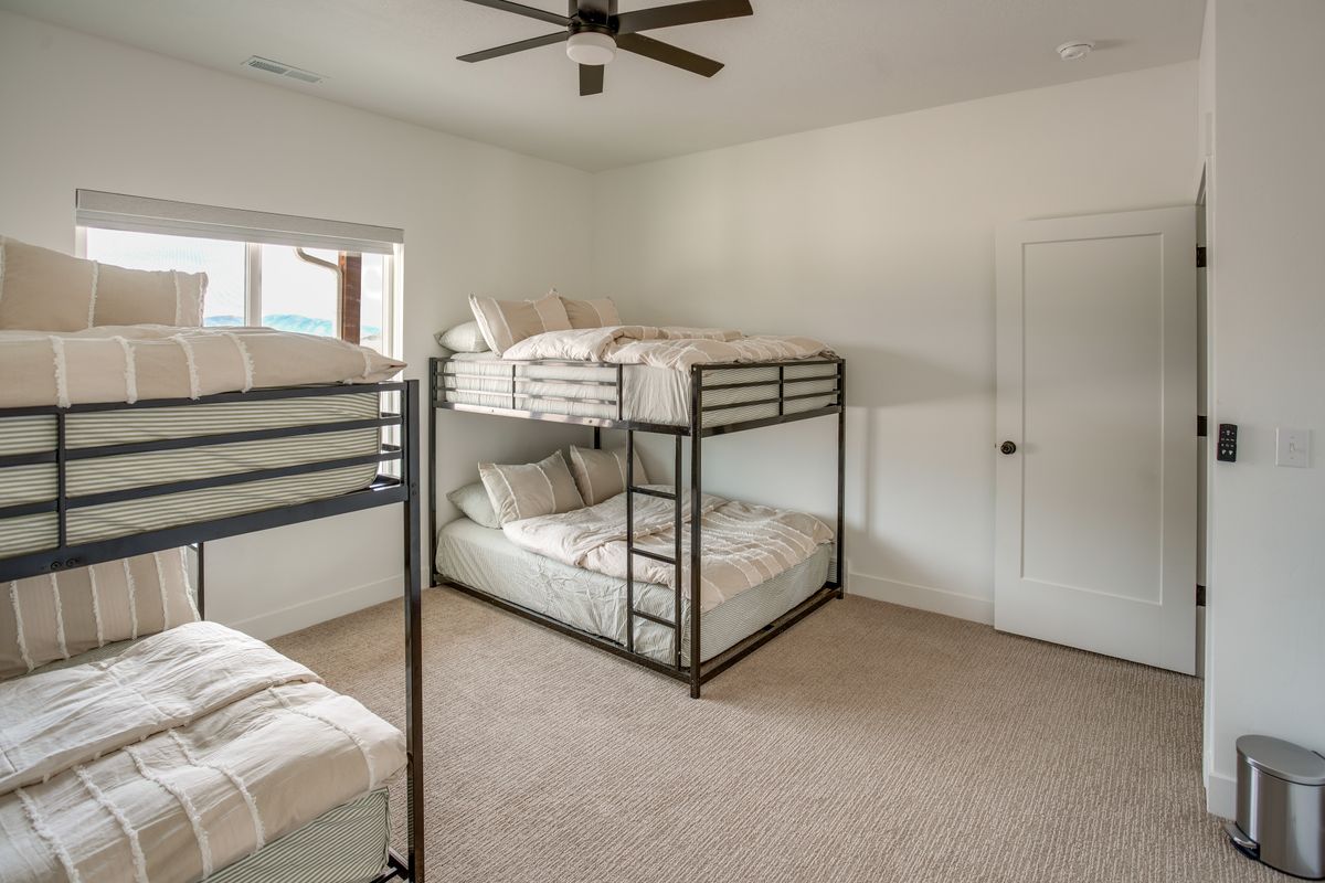 Carpeted room with a ceiling fan, a window, and a white interior door