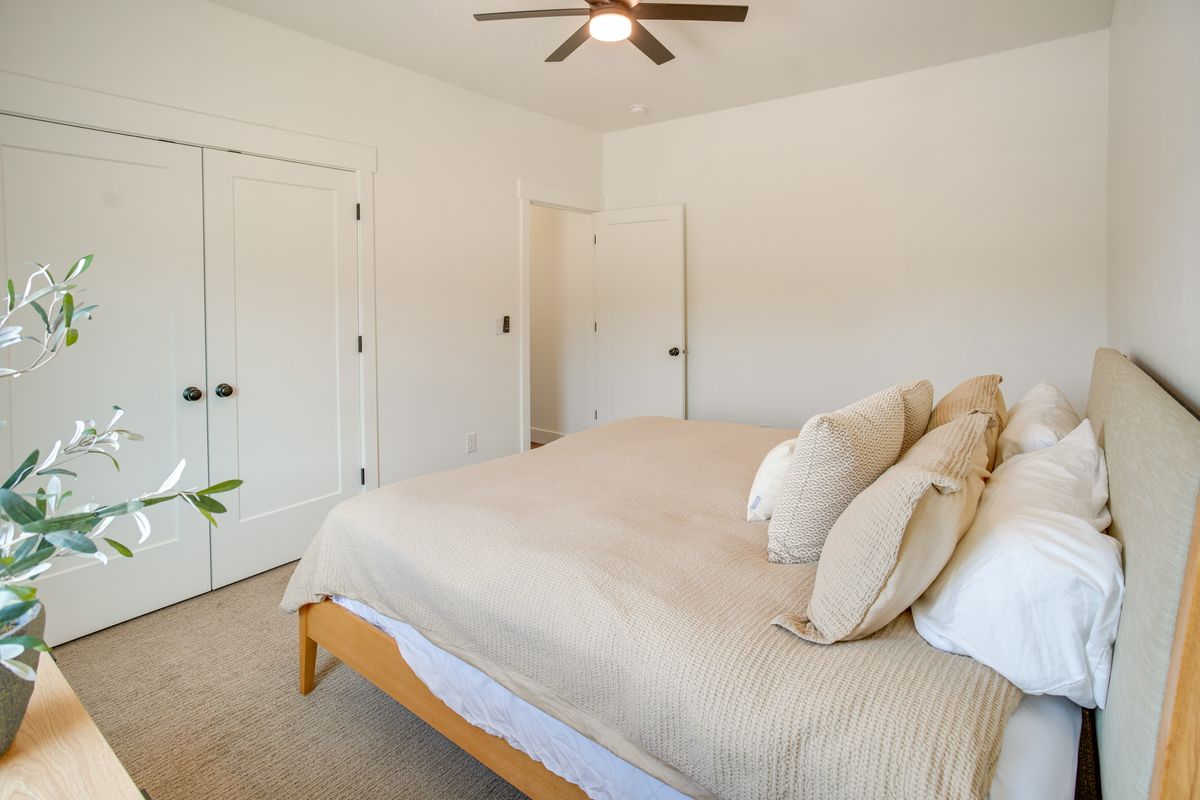 Bedroom featuring a ceiling fan, light-colored walls, and neutral-toned carpeting