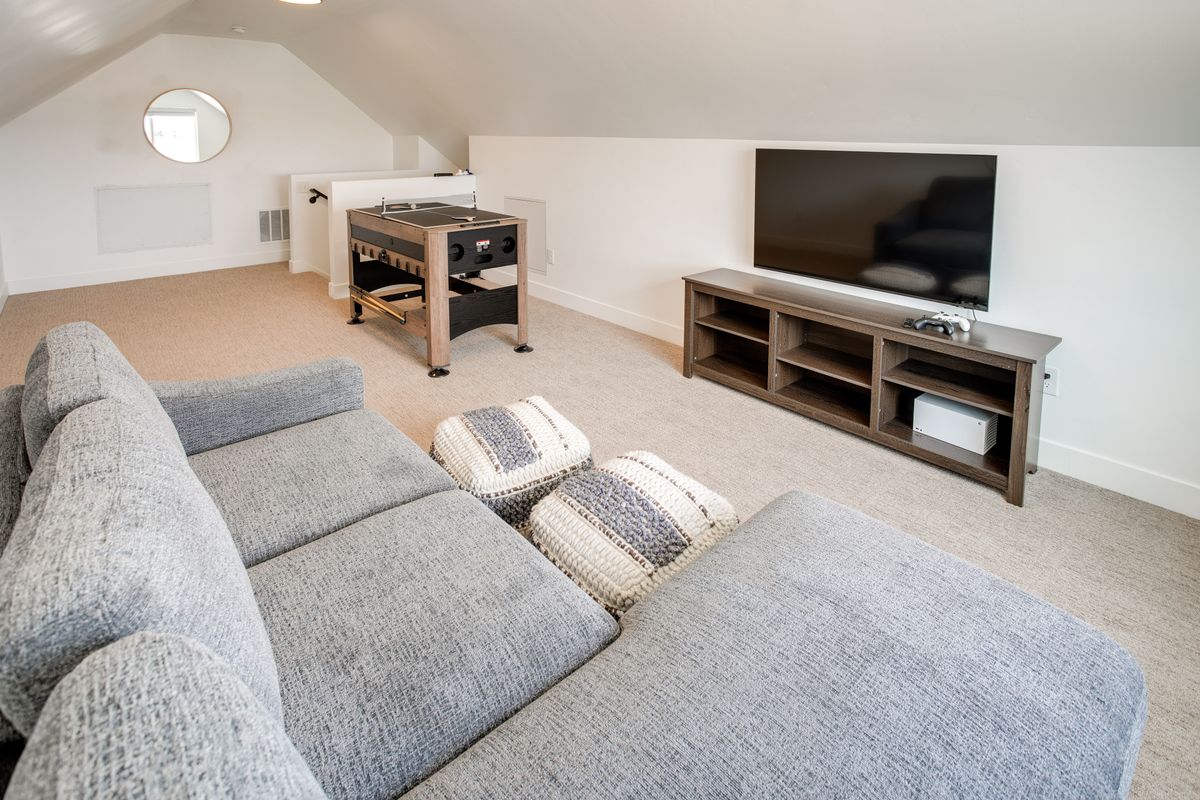 Expansive bonus room featuring sloped ceilings, recessed lighting, and neutral carpeting