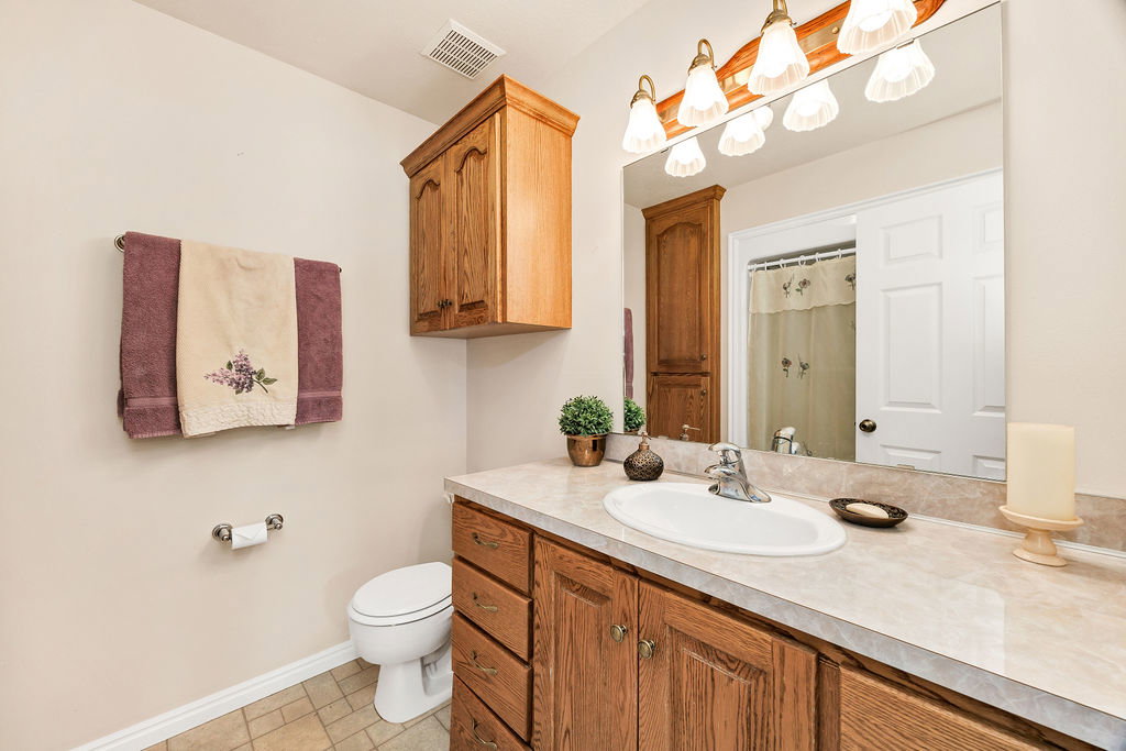Guest/2nd bathroom vanity featuring wood cabinetry, and a large wall-mounted mirror