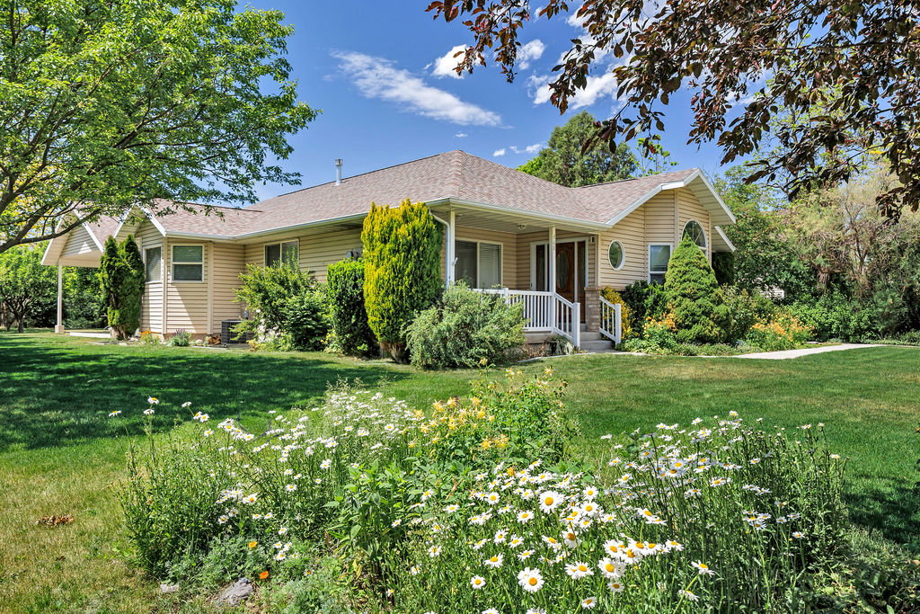 Ranch-style residence featuring beige siding, white trim, and a covered front porch with white railings
