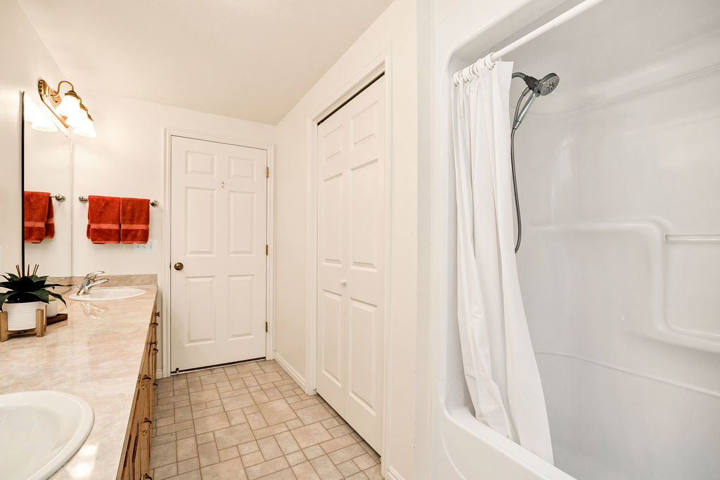 Basement bathroom featuring a full shower/tub combination with a large linen closet