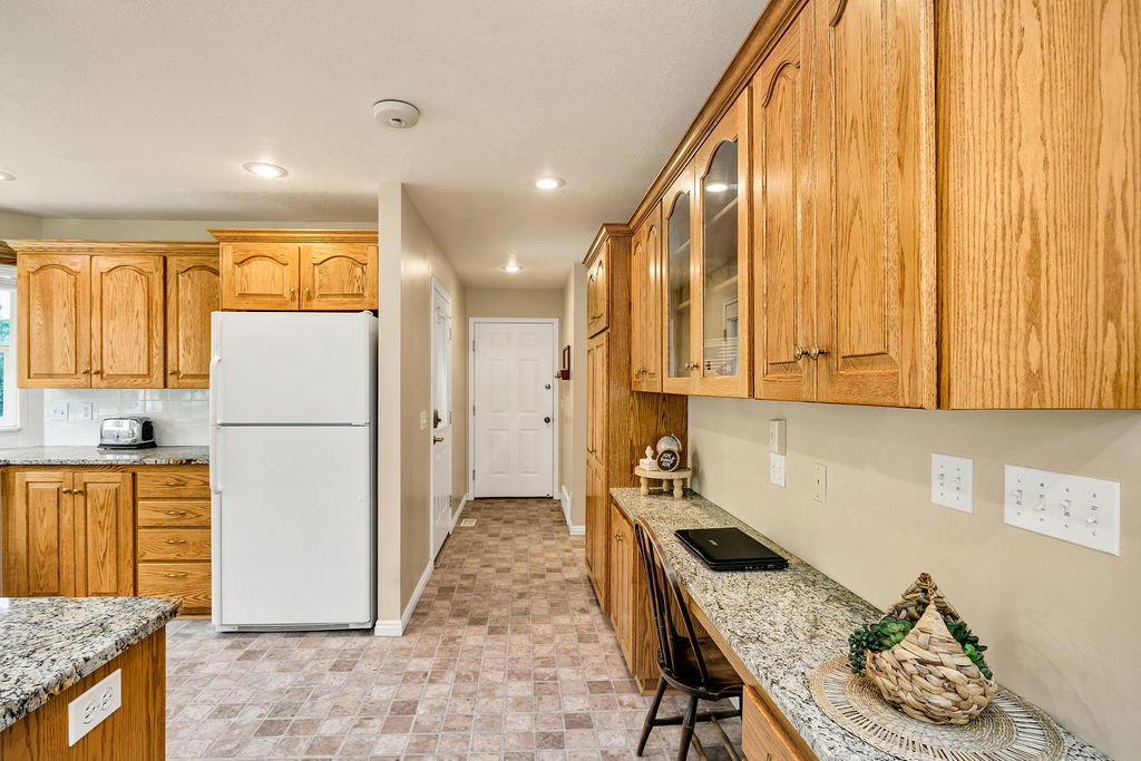 Kitchen hallway leads to back patio, garage, pantry and laundry, and the stairs that lead to the basement