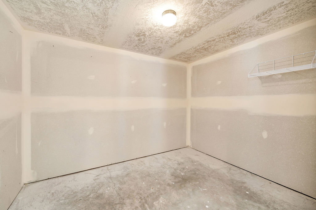 Huge unfinished basement storage room featuring texture & paint-ready walls, a concrete floor, and easily converted to a laundry room