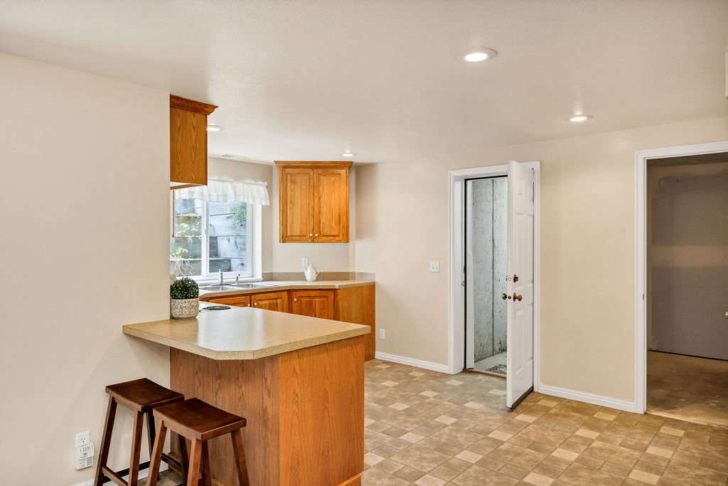 Second kitchen area featuring walk-out entrance and a large storage room-future basement laundry room