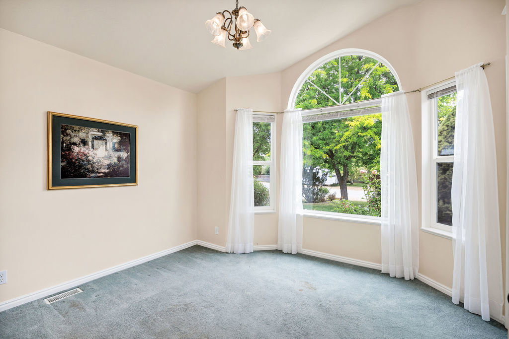 Front office/music/ 3rd bedroom featuring an arched window, additional sash windows, a vaulted ceiling, and a ceiling-mounted chandelier