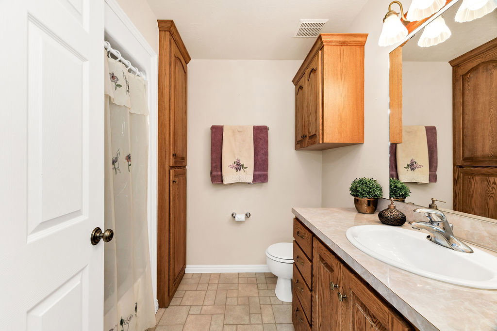 Bathroom featuring a single-basin vanity with wood cabinetry and a tub/shower combo