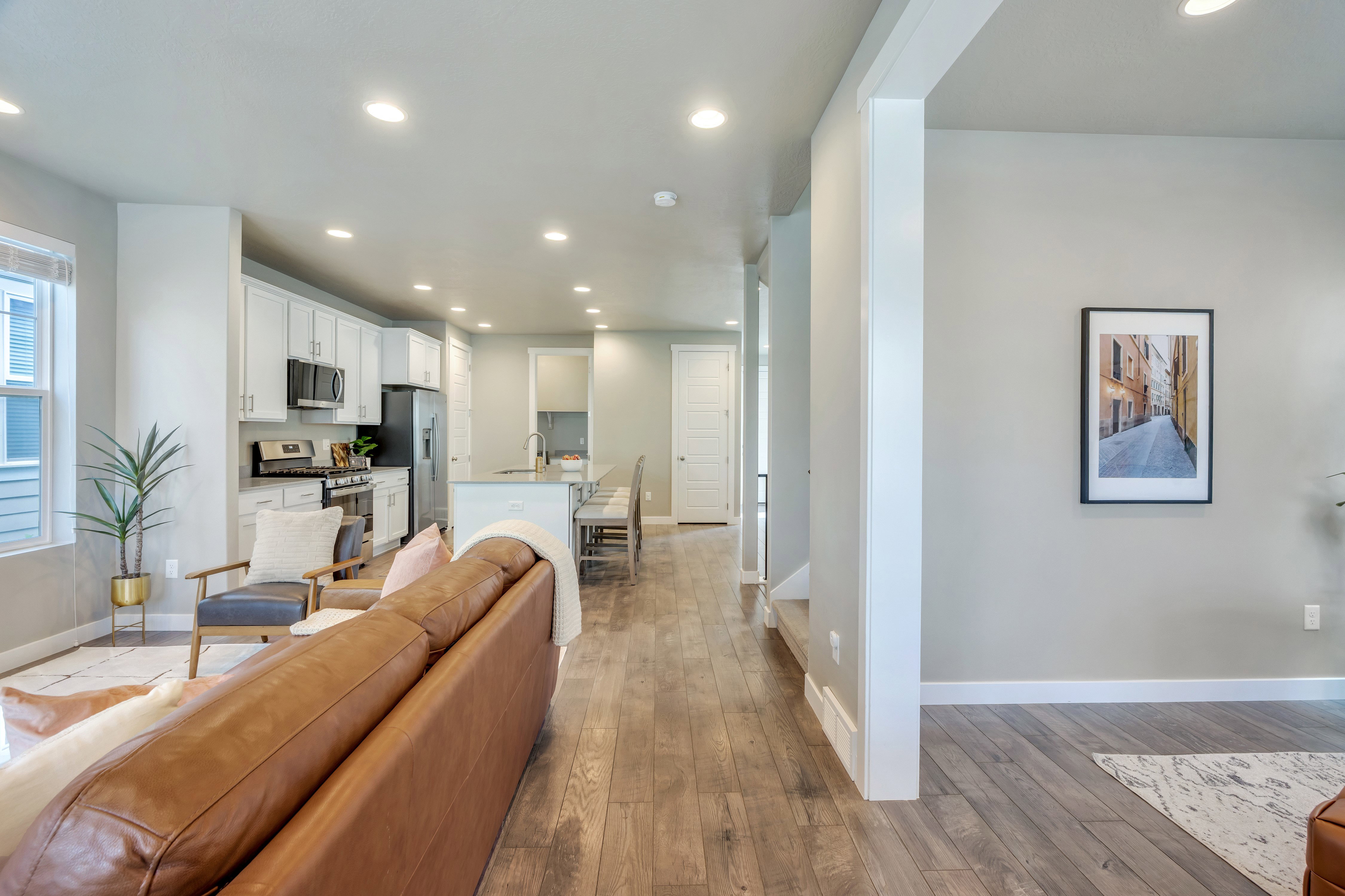 Open-concept living space featuring wood-finish flooring, recessed lighting, and a neutral wall palette