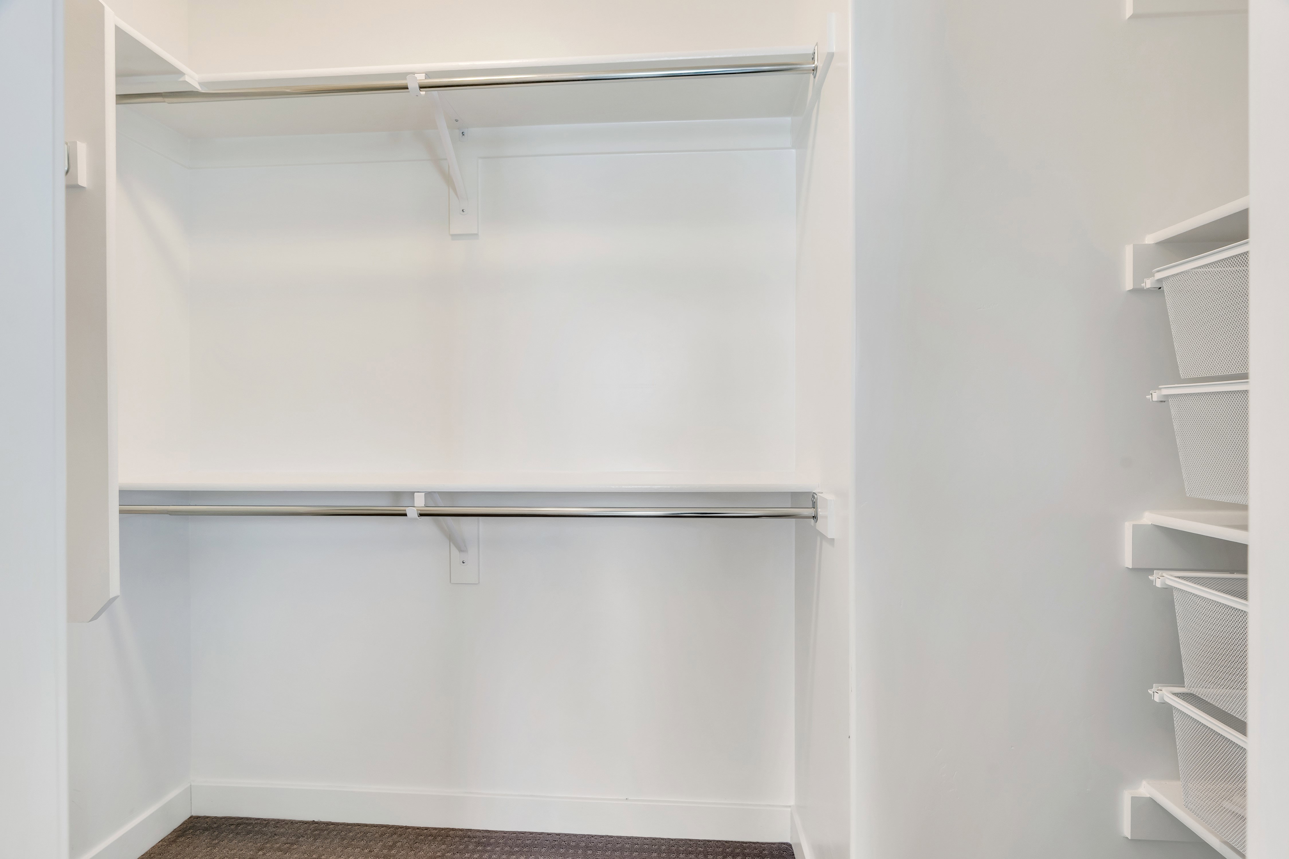 Walk-in closet with white shelving and hanging rods