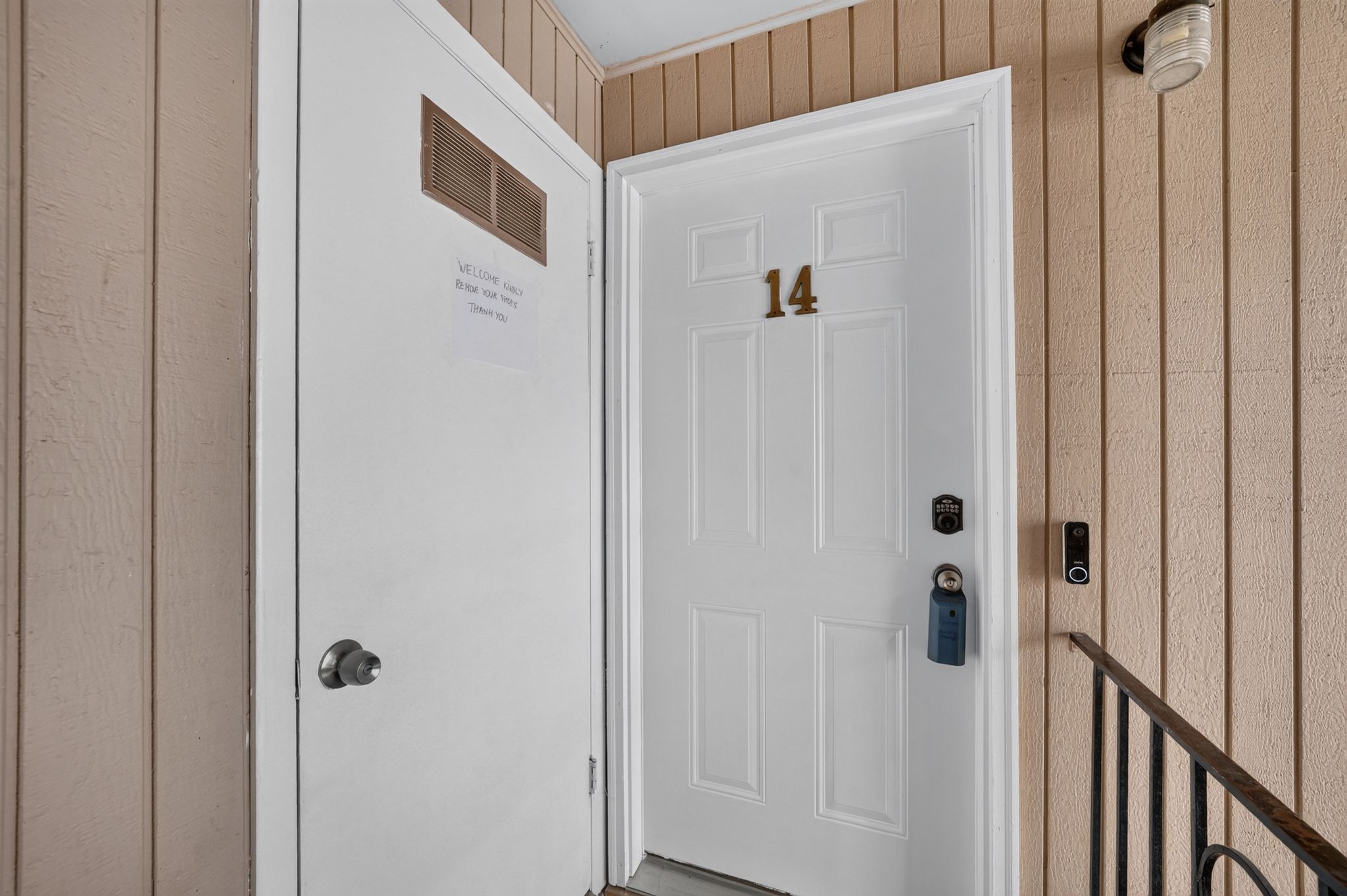 Entry door with paneled design and brass numbering