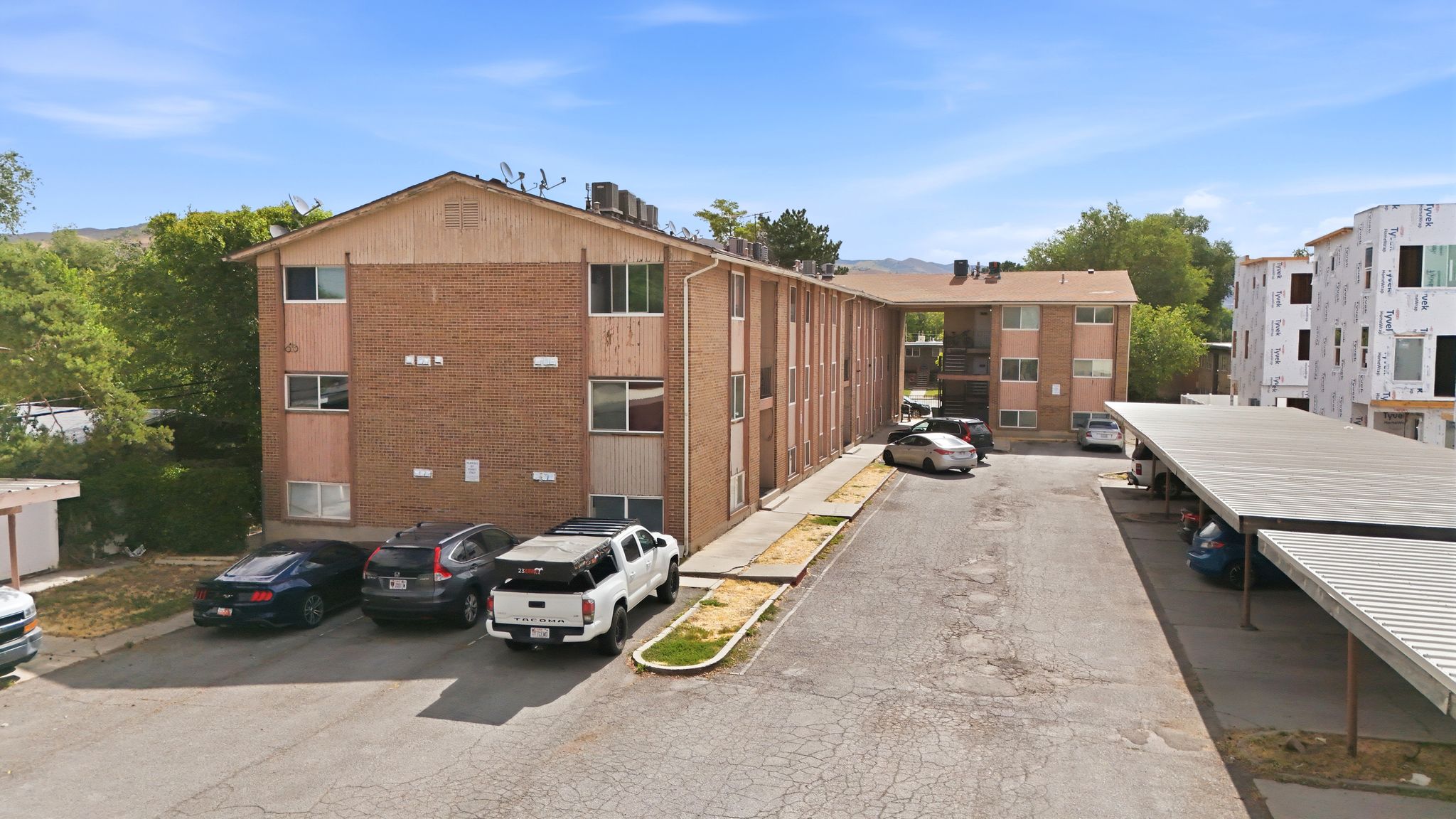 Brick apartment complex featuring multiple stories and a pitched roofline