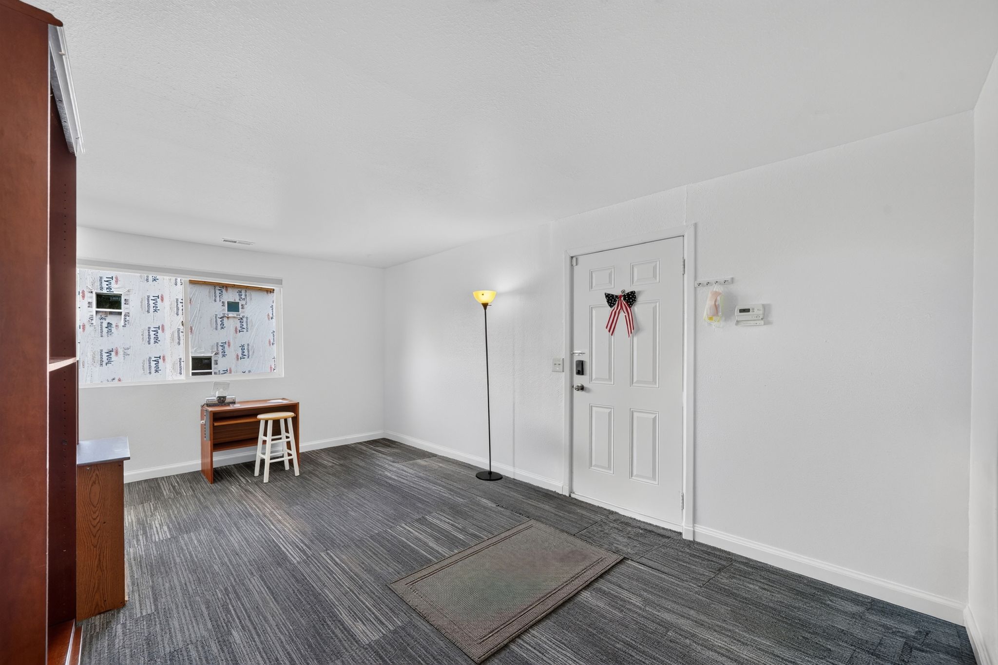 Spacious room featuring gray wood-finish flooring, white walls, and a multi-pane window