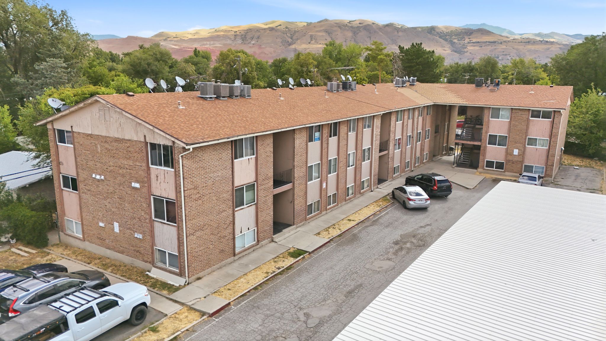 Multi-unit building featuring brick construction, a brown shingle roof, and multiple exterior balconies