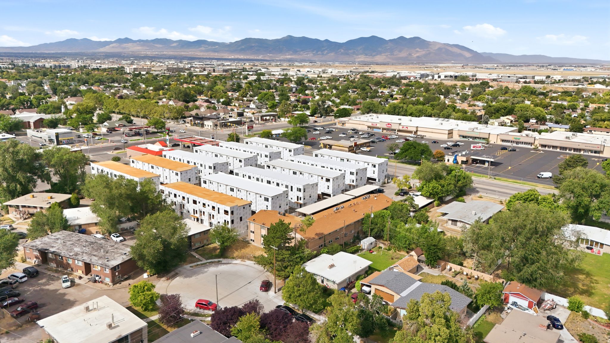 Aerial perspective showcasing a residential area with varied housing structures, including multi-story apartment buildings and single-story homes