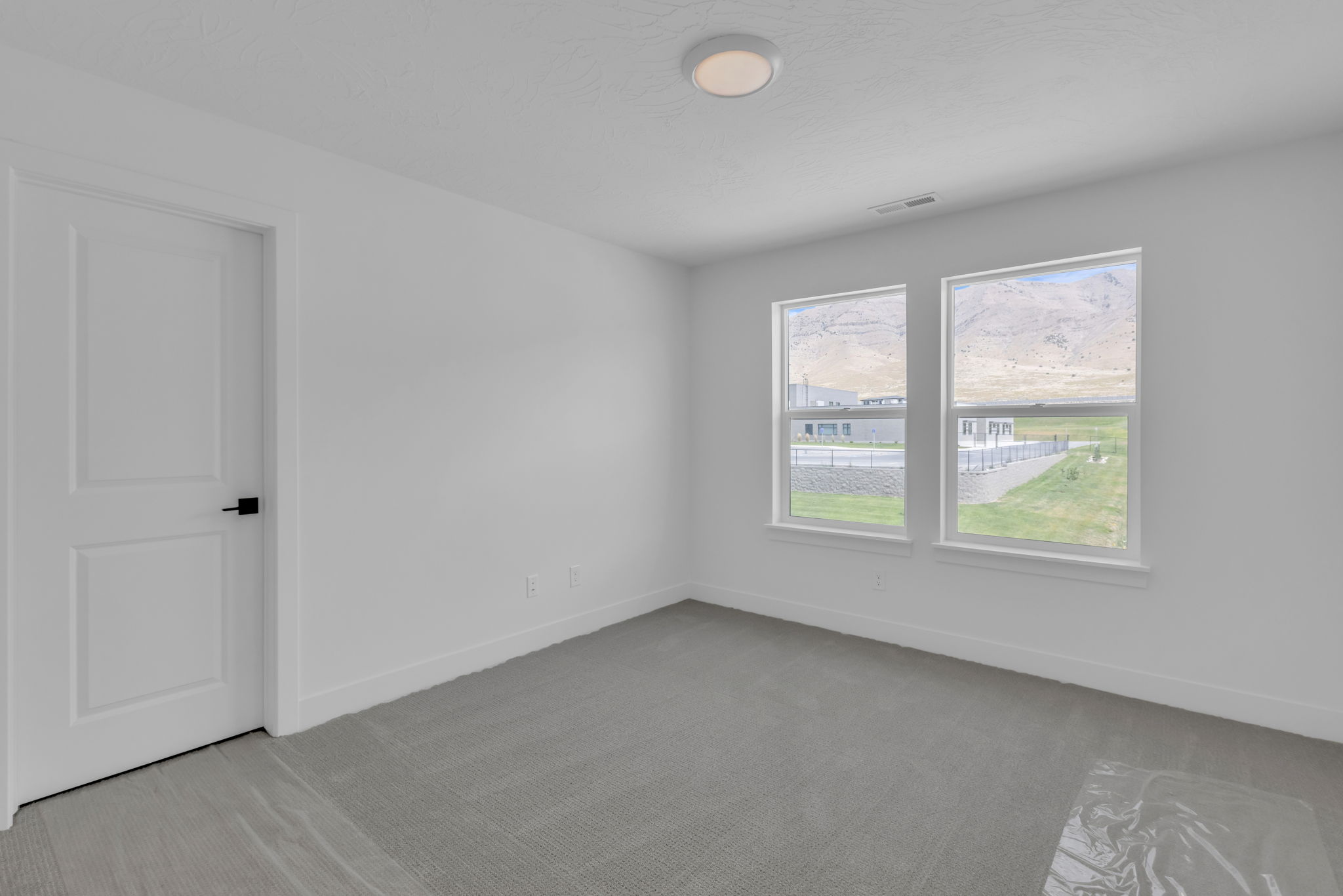 Bright bedroom and a large window offering expansive outdoor scenery.