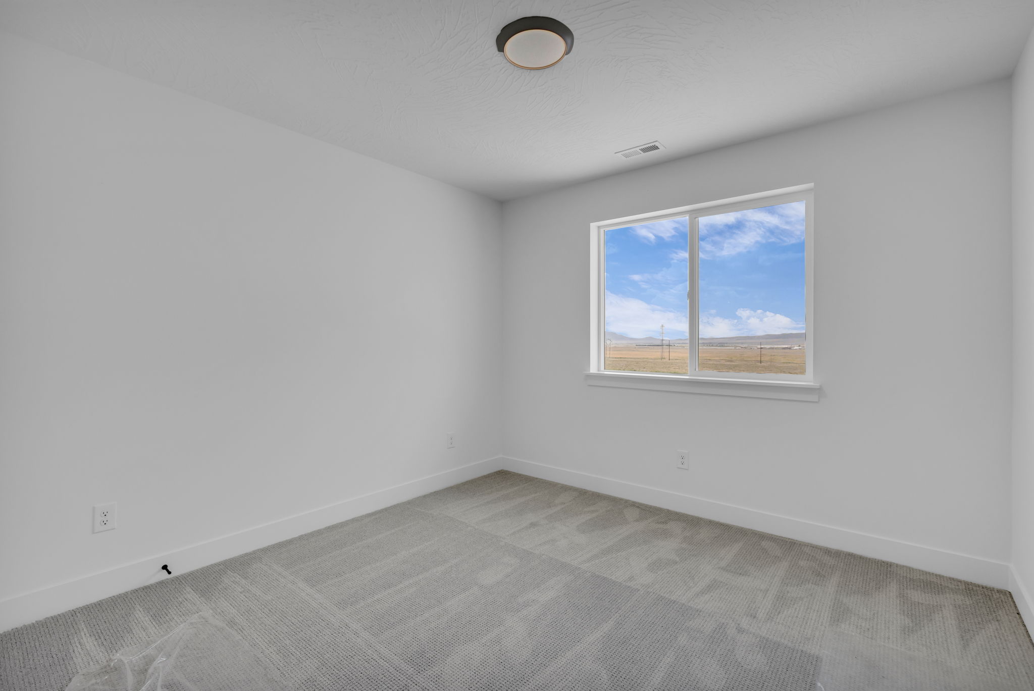 Bright bedroom and a large window offering expansive outdoor scenery.