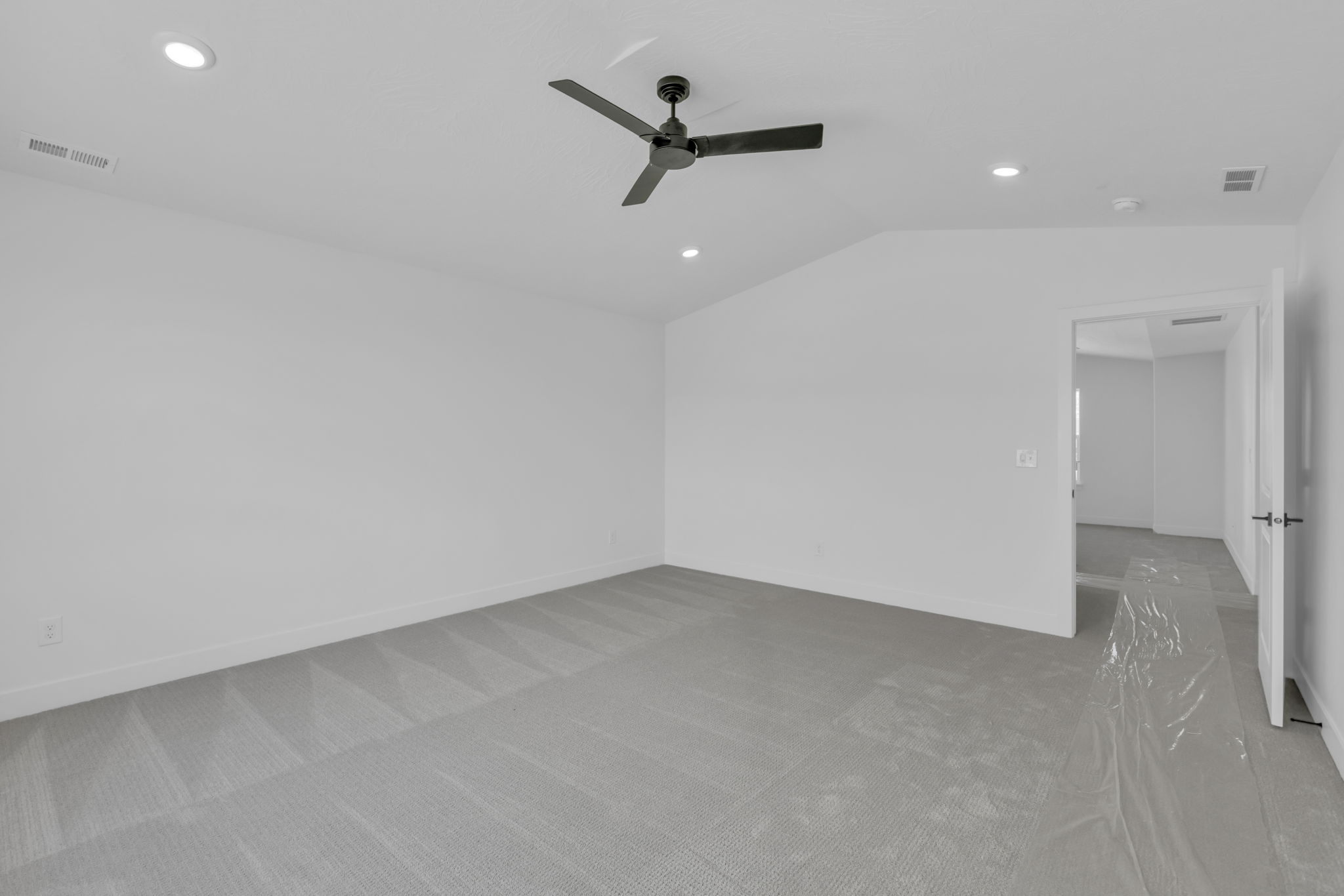 Vaulted primary  bedroom featuring LED lighting, contemporary ceiling fan, looking out to bedroom entrance.