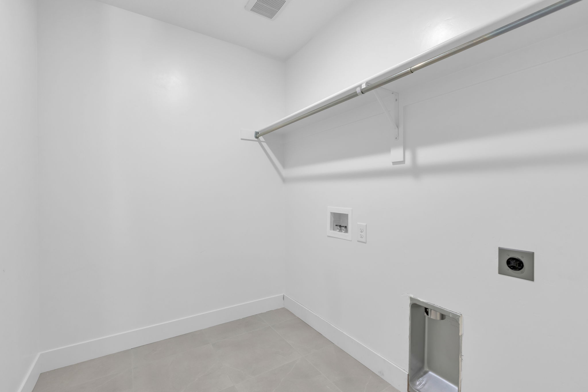 Dedicated laundry area featuring a light-colored tile floor.