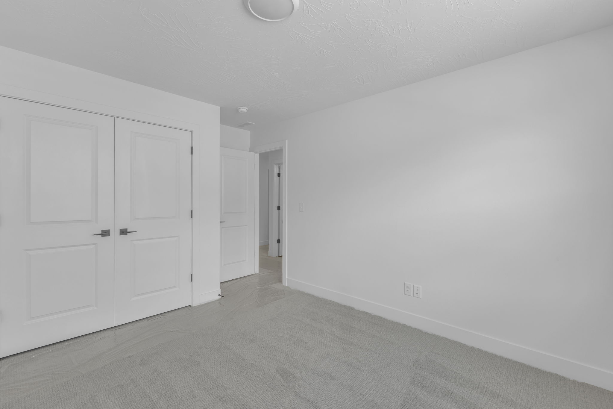 Bright bedroom featuring closet with double doors.