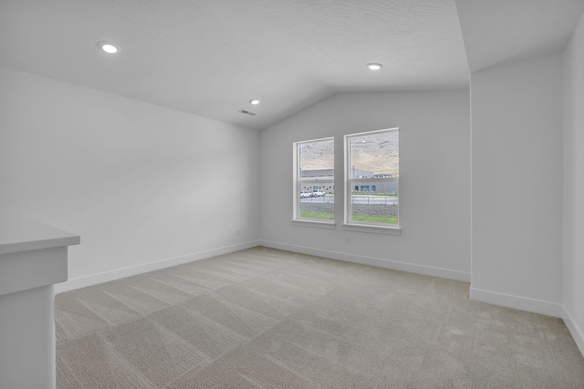 Large vaulted loft space featuring large windows with beautiful mountain views.
