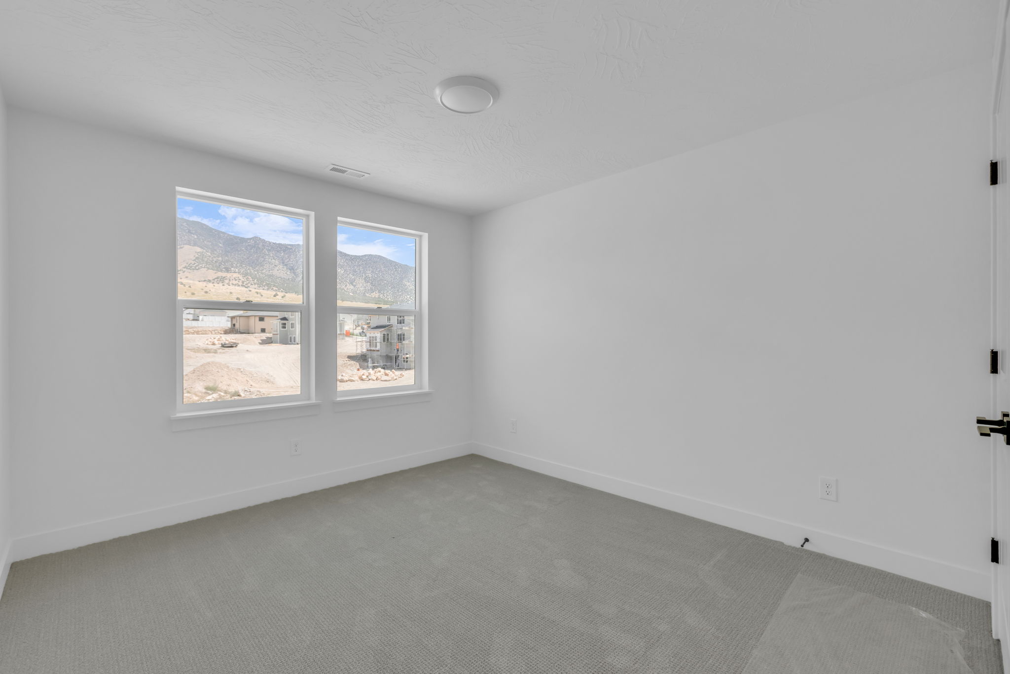 Bright bedroom and a large window offering expansive outdoor scenery.