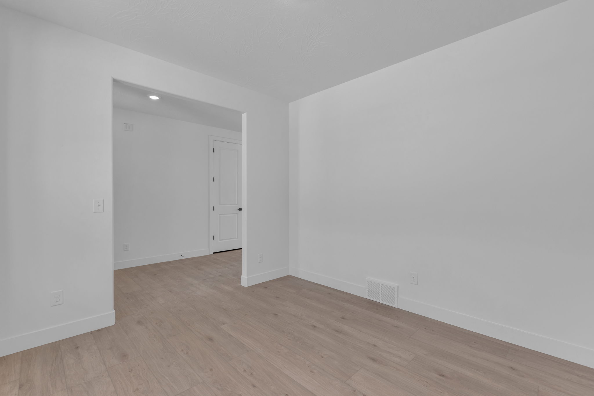 Bright flex space with large windows looking towards entryway.