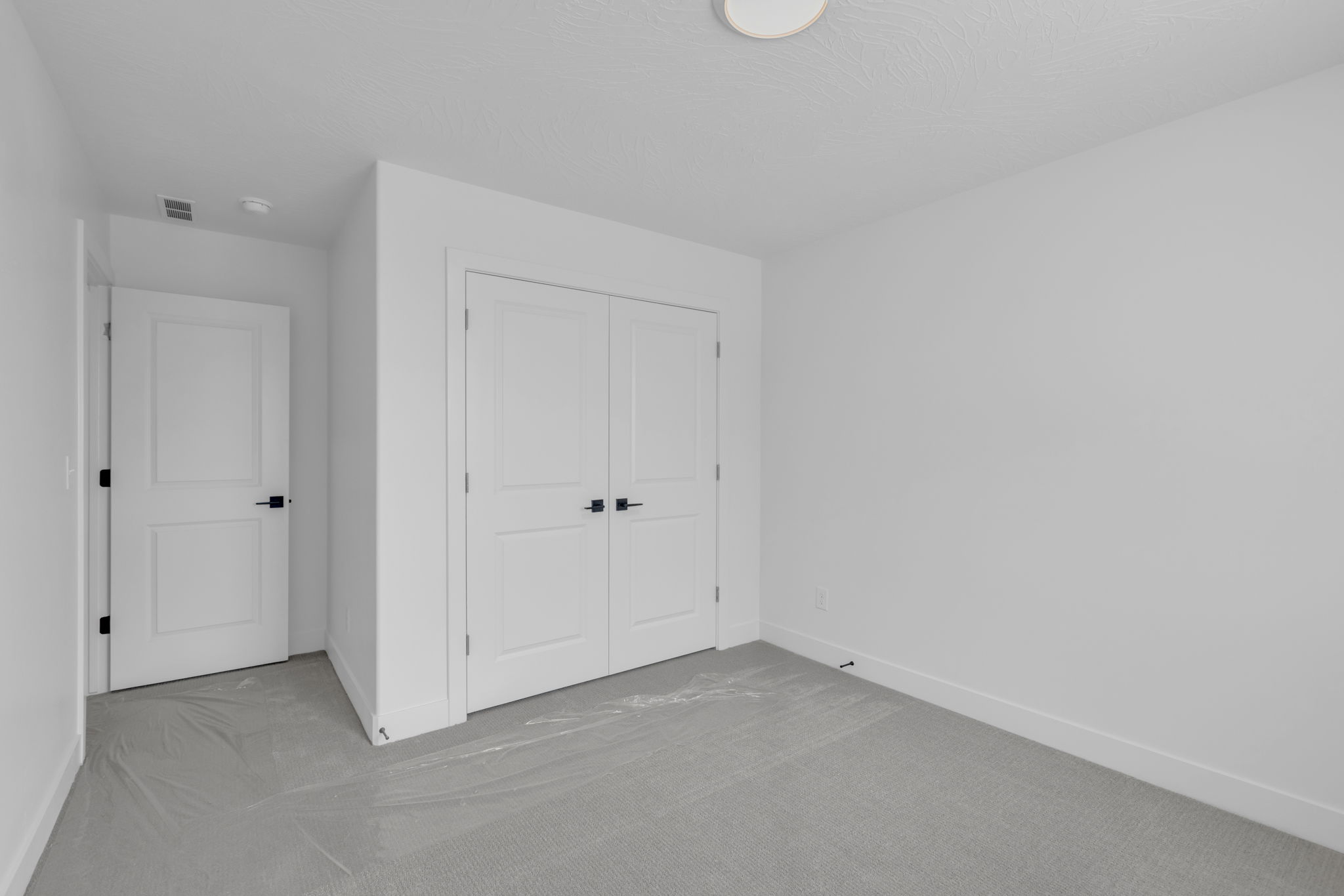 Bright bedroom featuring closet with double doors.