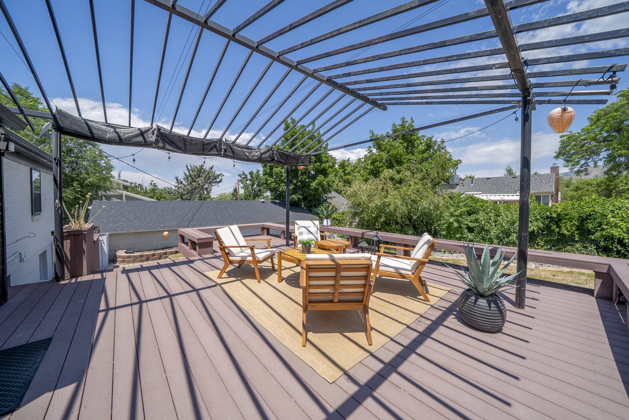 Expansive outdoor deck featuring composite decking and a black metal pergola