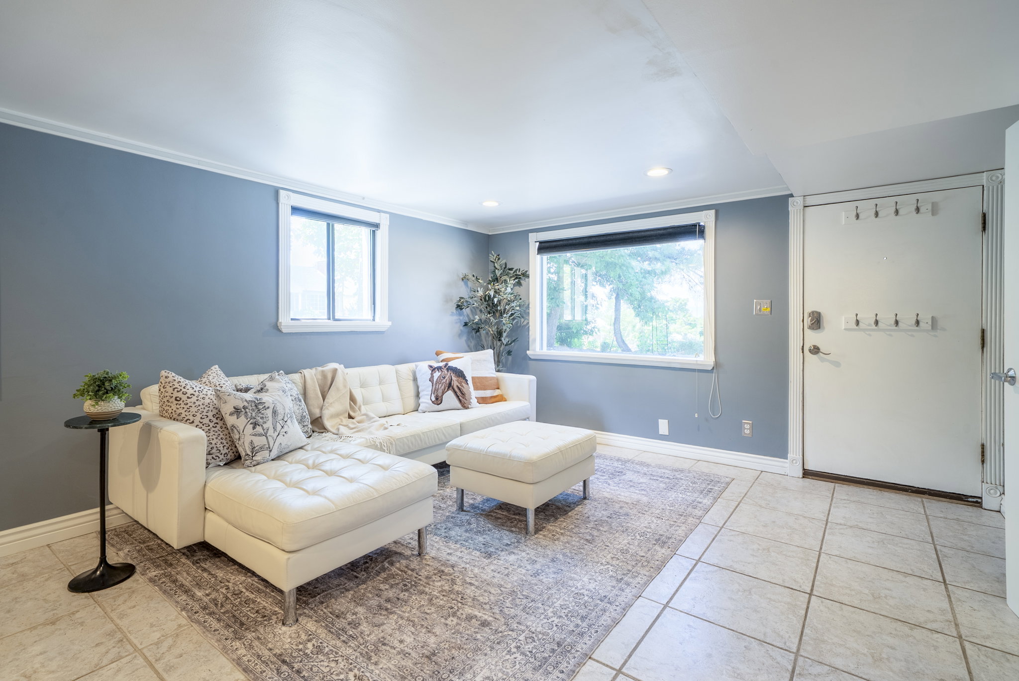 Recessed lighting illuminates the tiled flooring and light blue walls