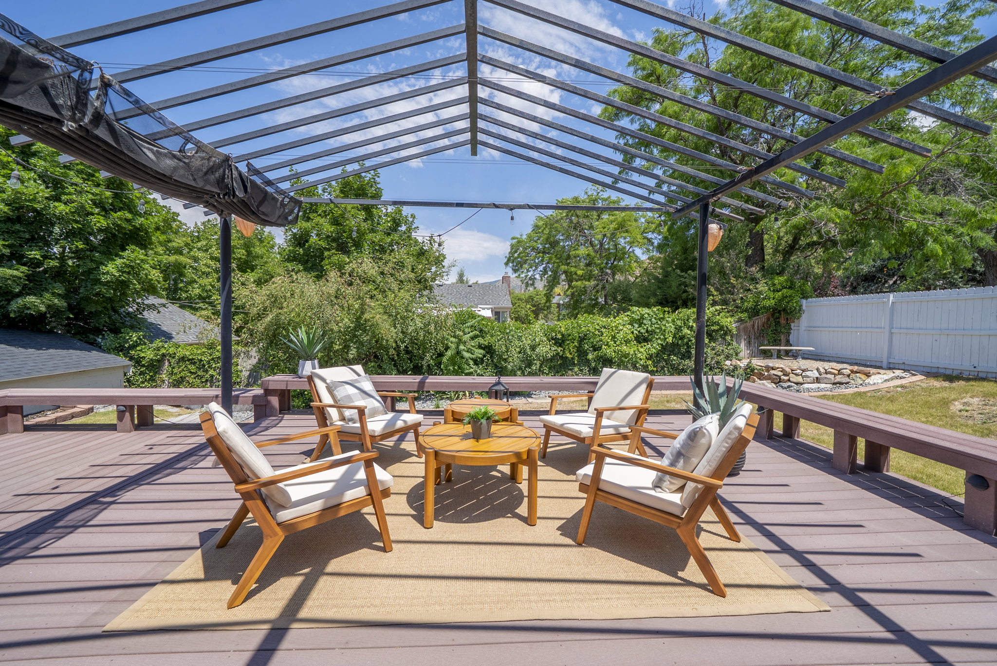 Expansive outdoor deck featuring a contemporary pergola with a retractable shade