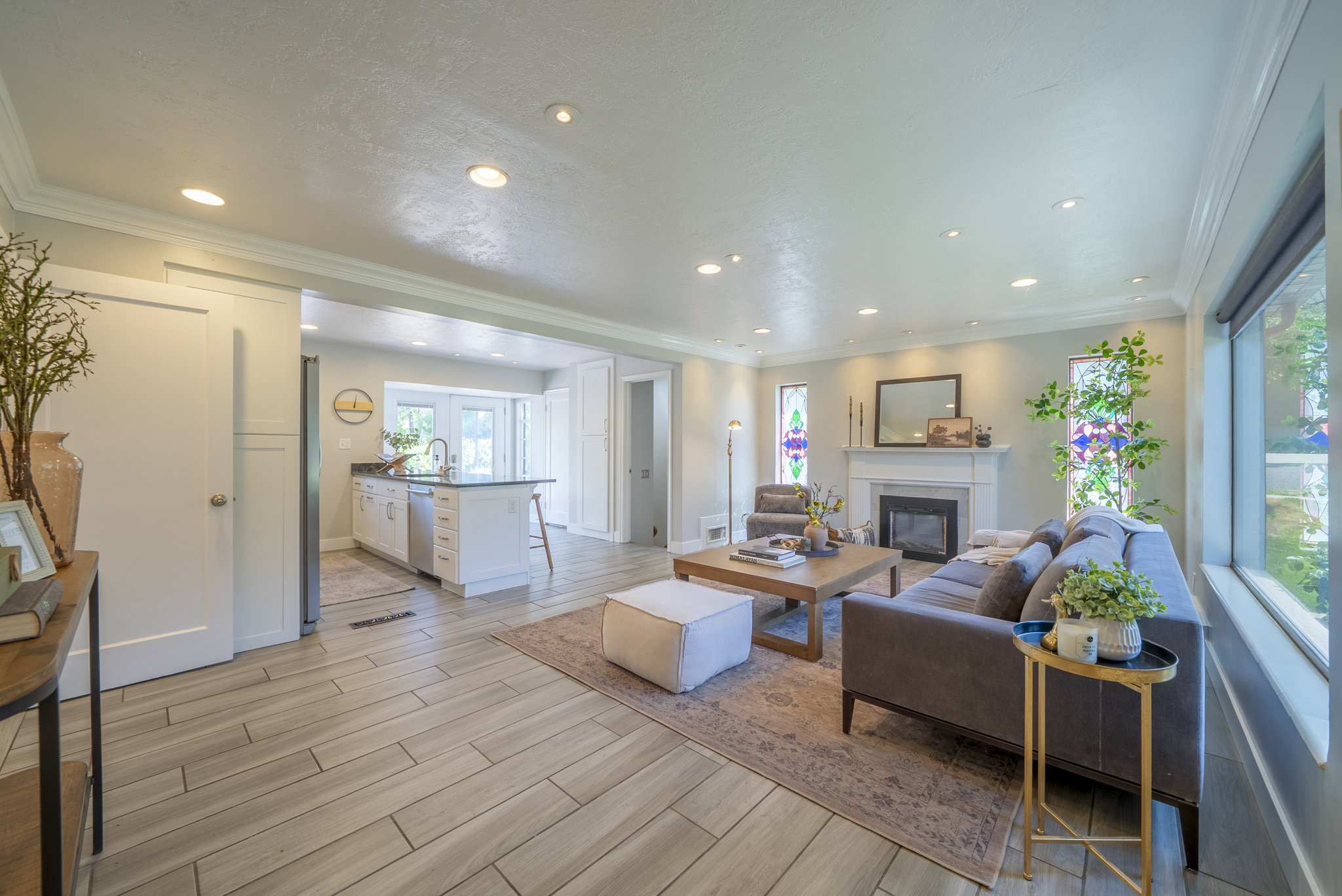 Spacious living area featuring wood-finish flooring, recessed lighting, and a fireplace with a mantel