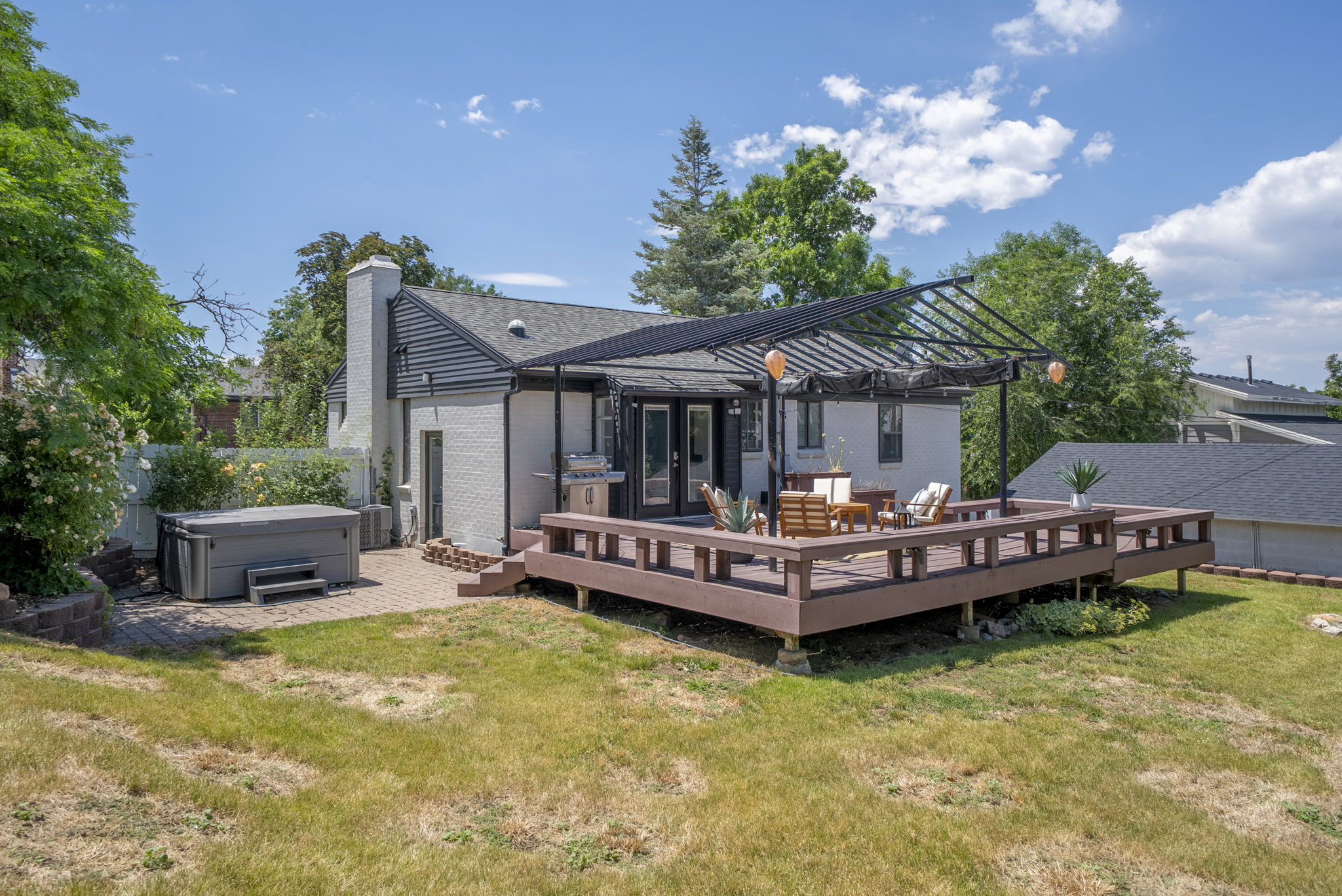Expansive multi-level wood deck featuring a black metal pergola