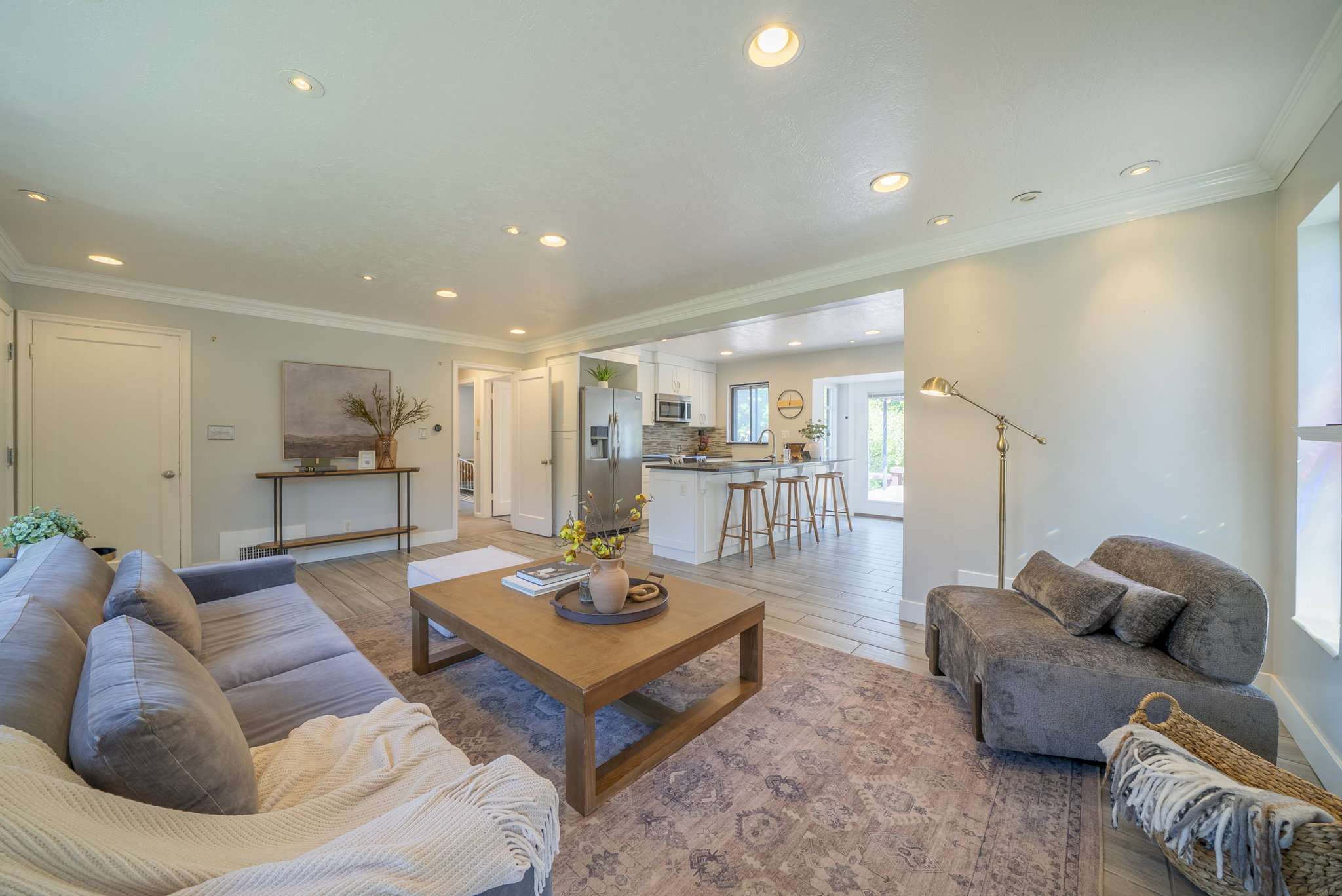 Open-concept living area featuring recessed lighting, crown molding, and wood-finish flooring