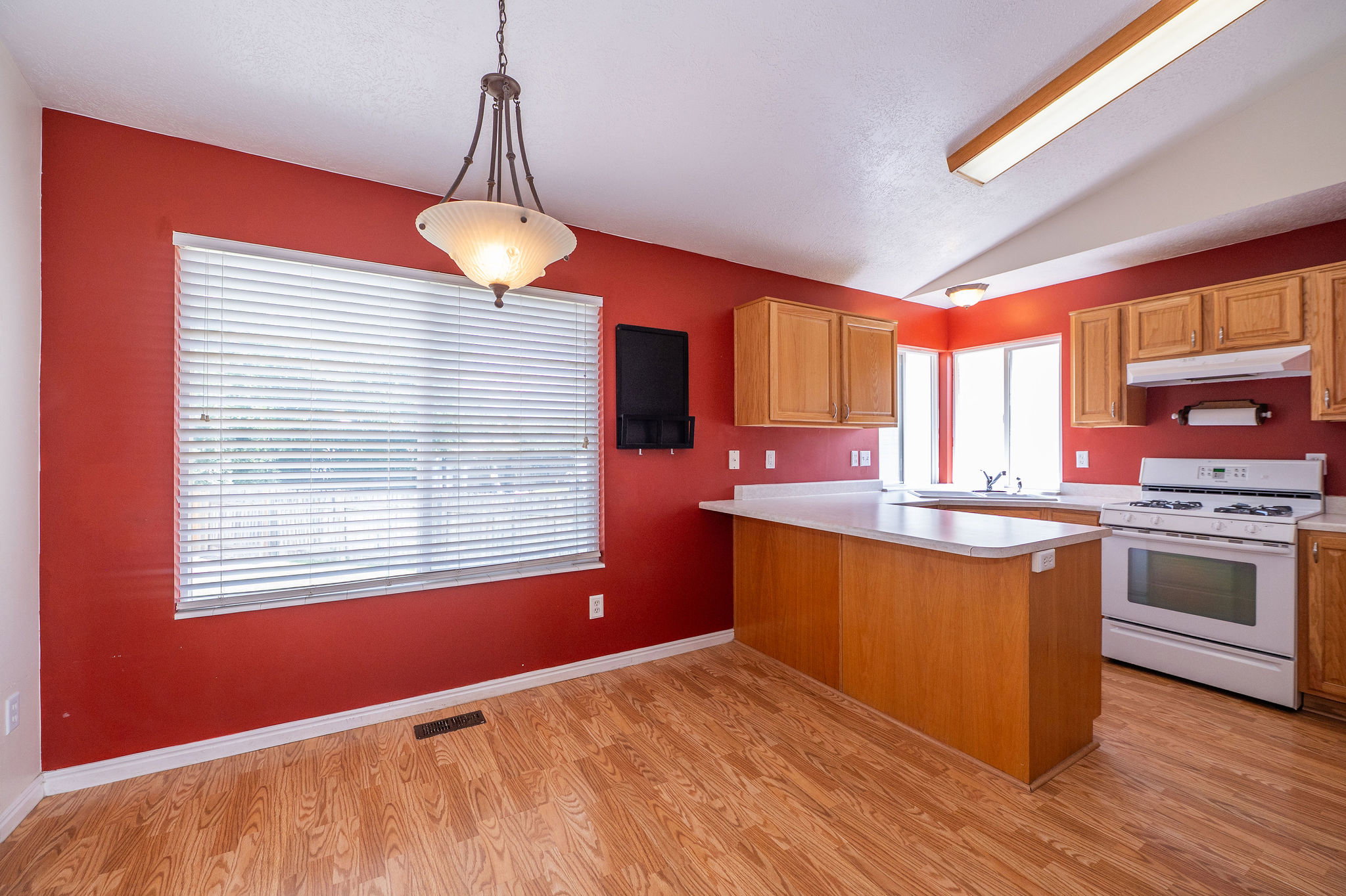 Dining area with wood-finish flooring and a contemporary chandelier